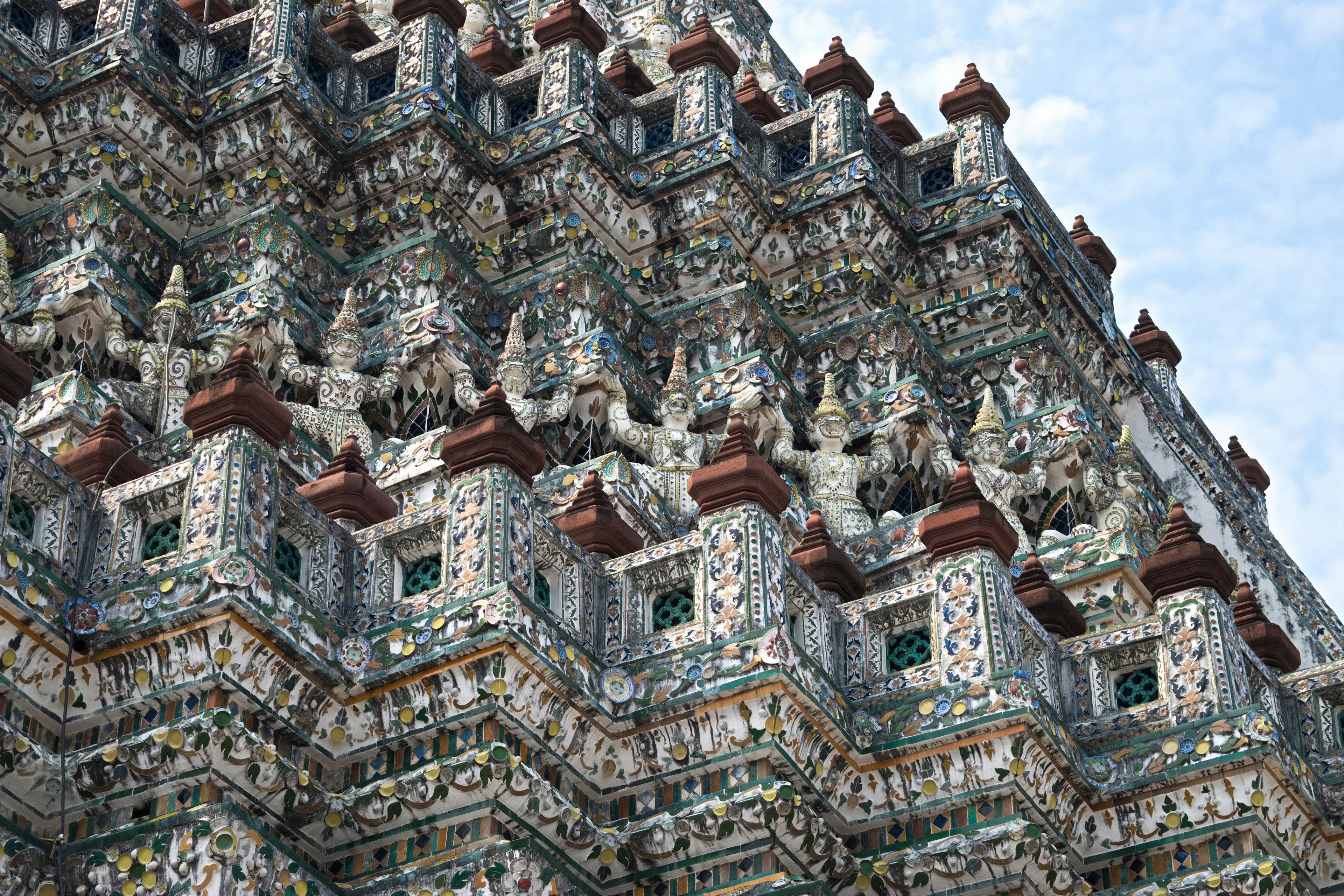 Decorazioni murali dettagliate e guglie del Wat Arun a Bangkok