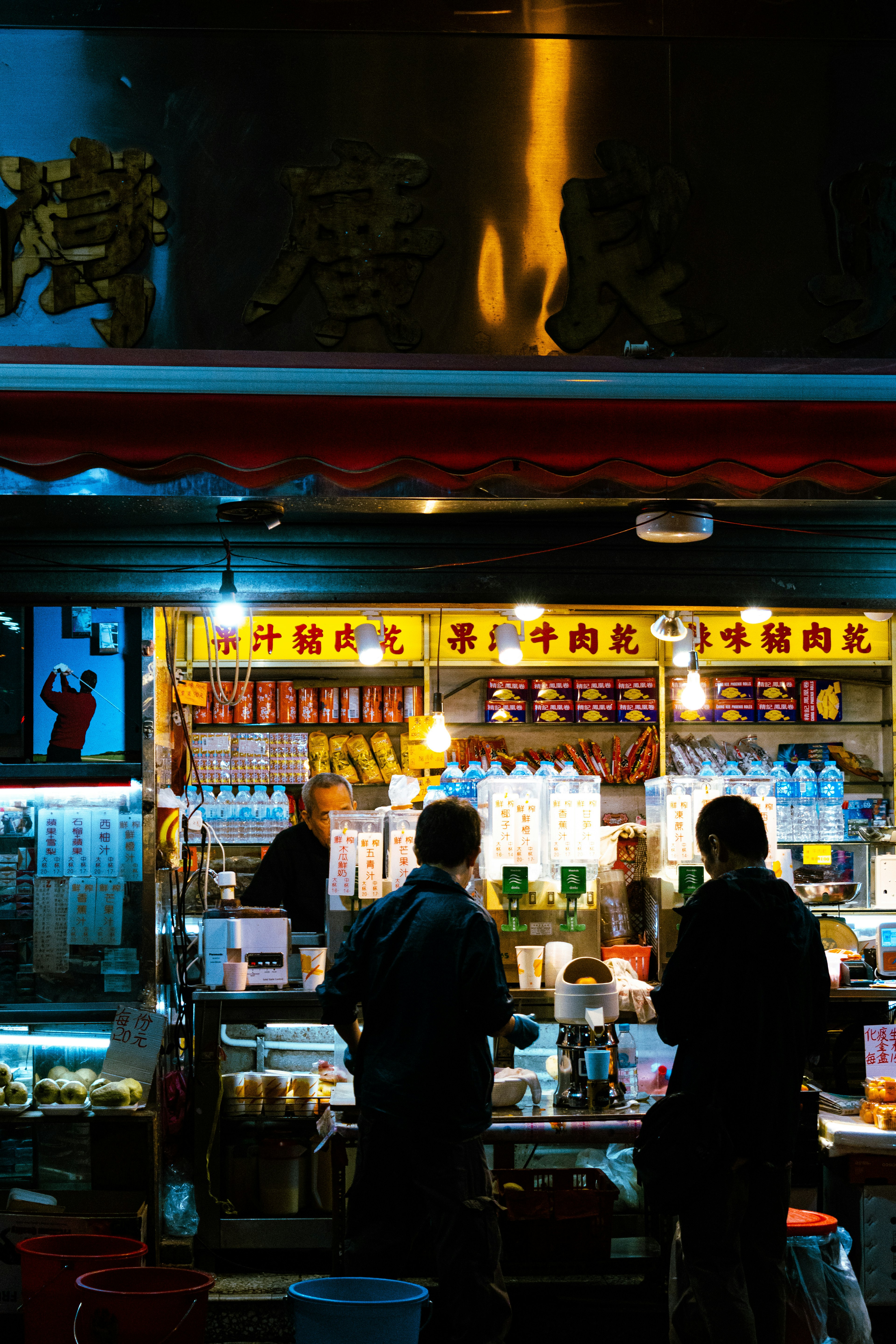 Two men choosing drinks at a night market stall