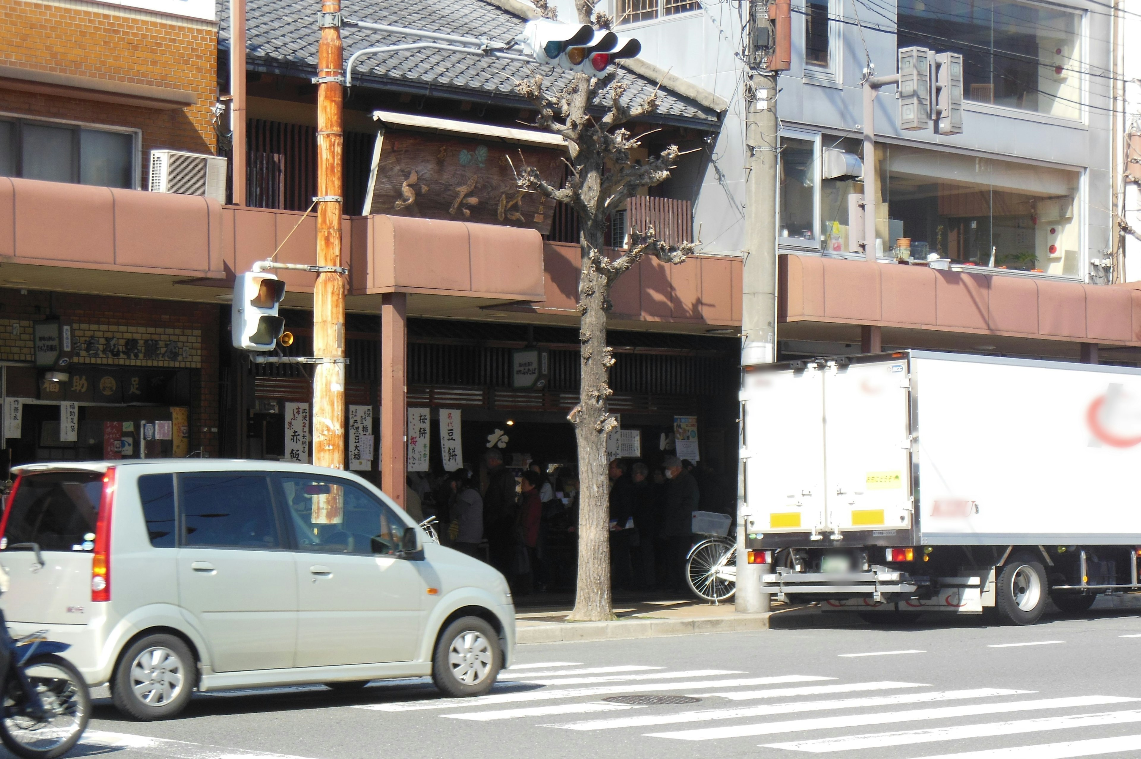 Vue de la rue avec un feu de circulation et un magasin des voitures et un camion passent