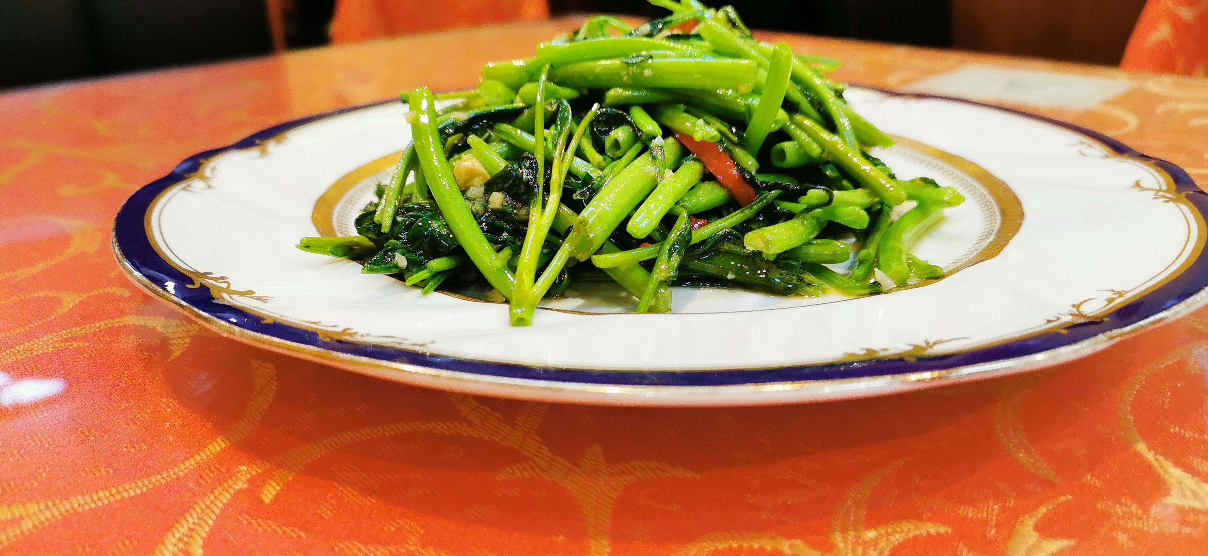 Un piatto di verdure verdi vivaci splendidamente disposte