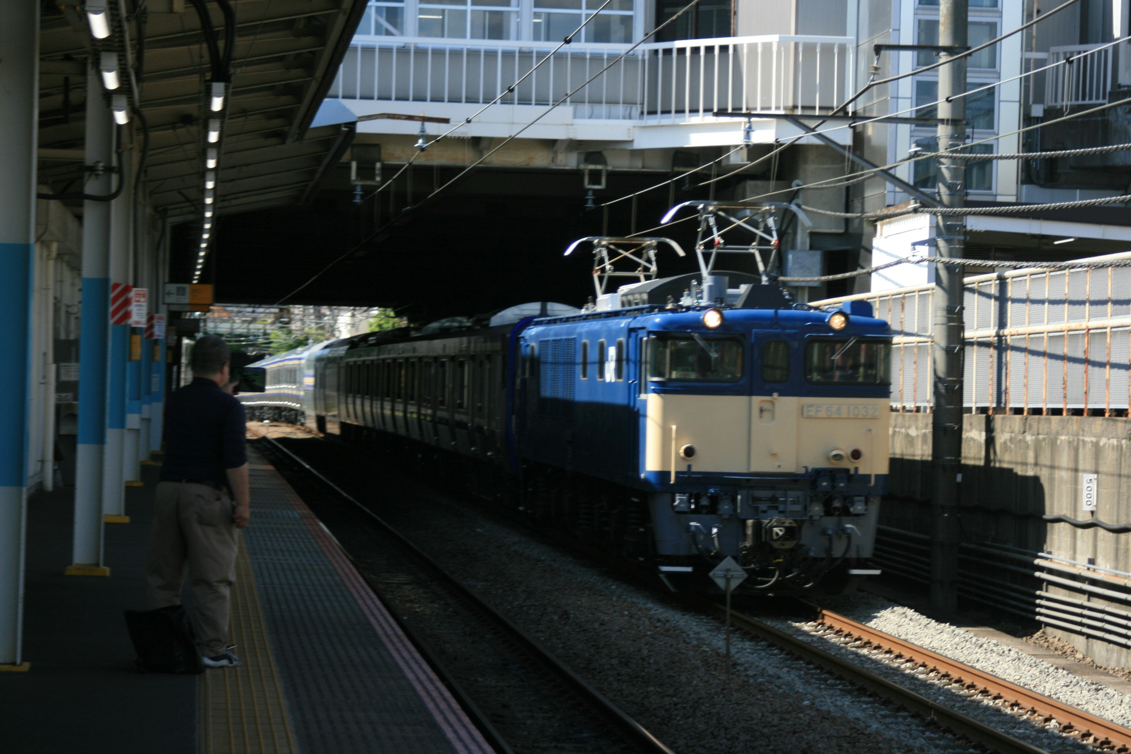 Blue electric locomotive at a train station