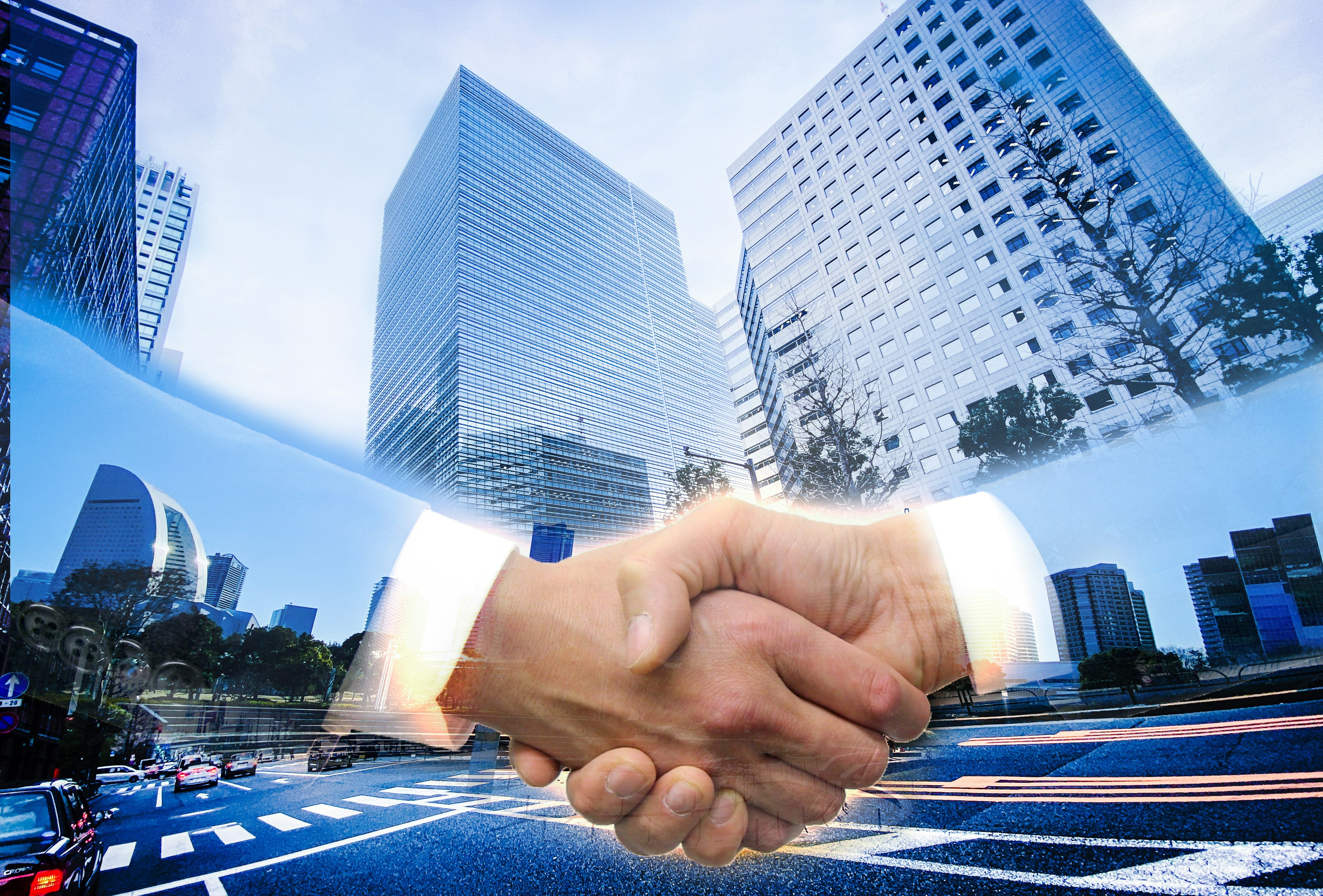 Image of a handshake with a cityscape in the background