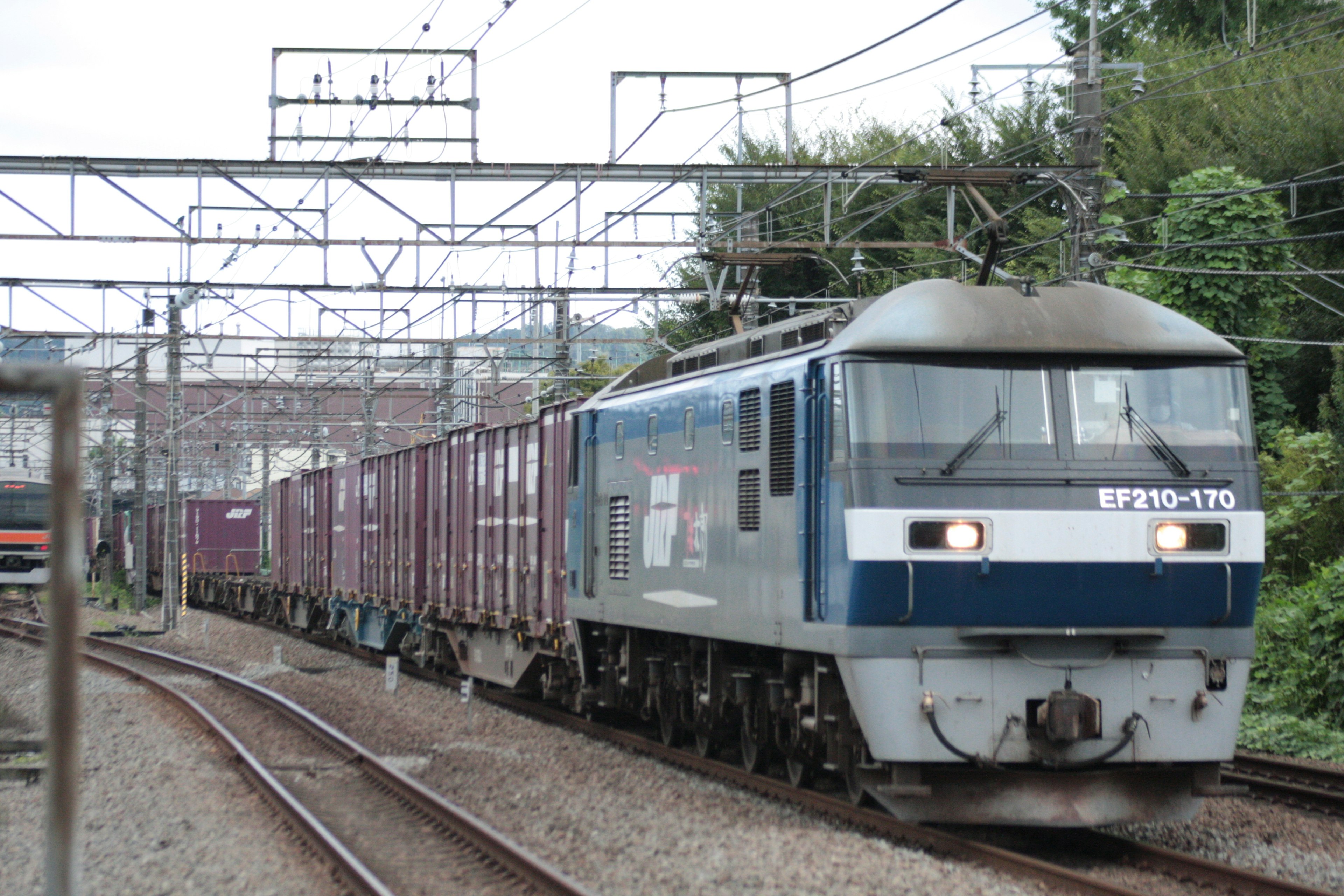 青い貨物列車が線路を走る風景