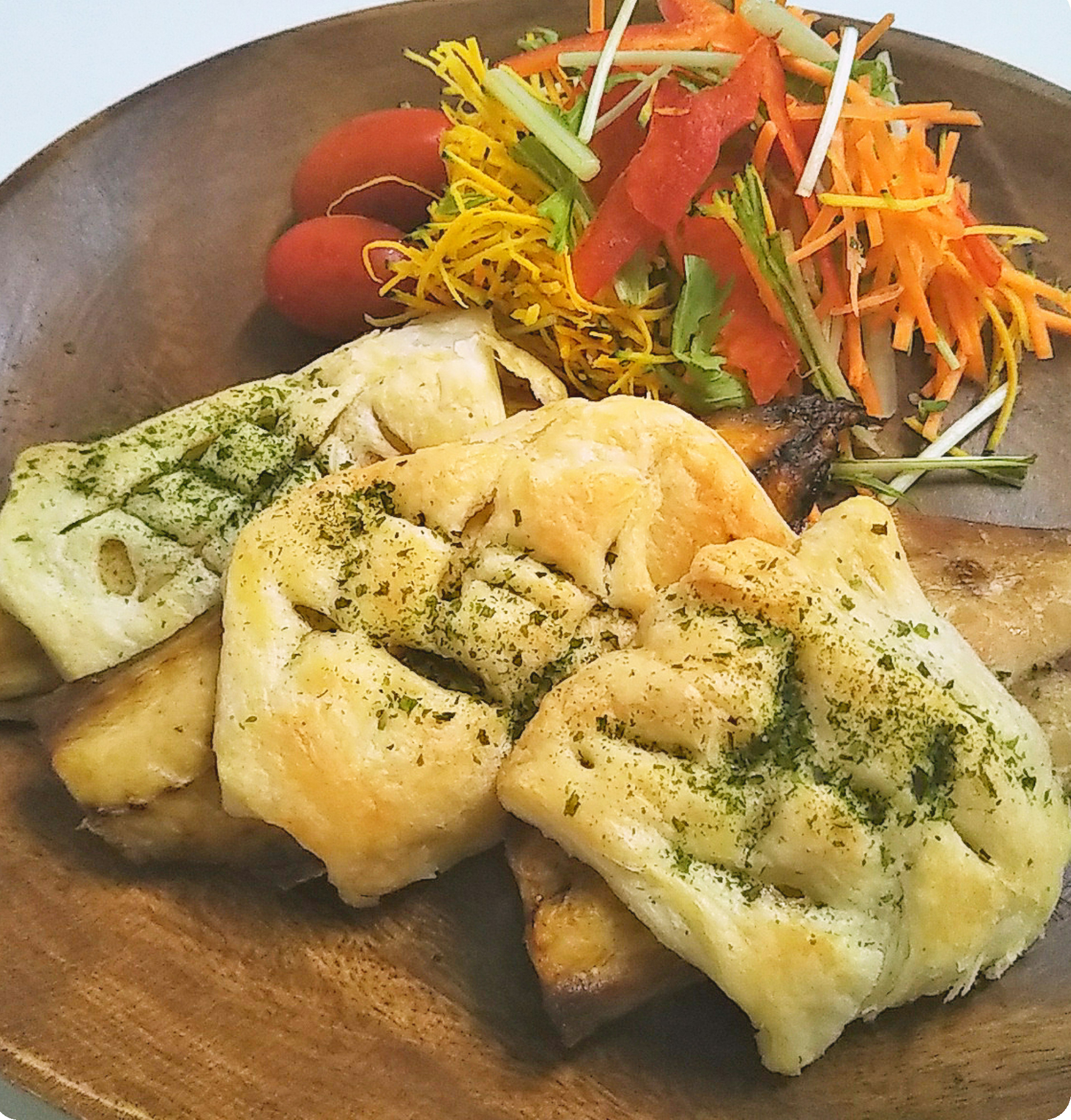 Ein köstliches Fischgericht, serviert mit einem frischen Salat auf einem Holzbrett