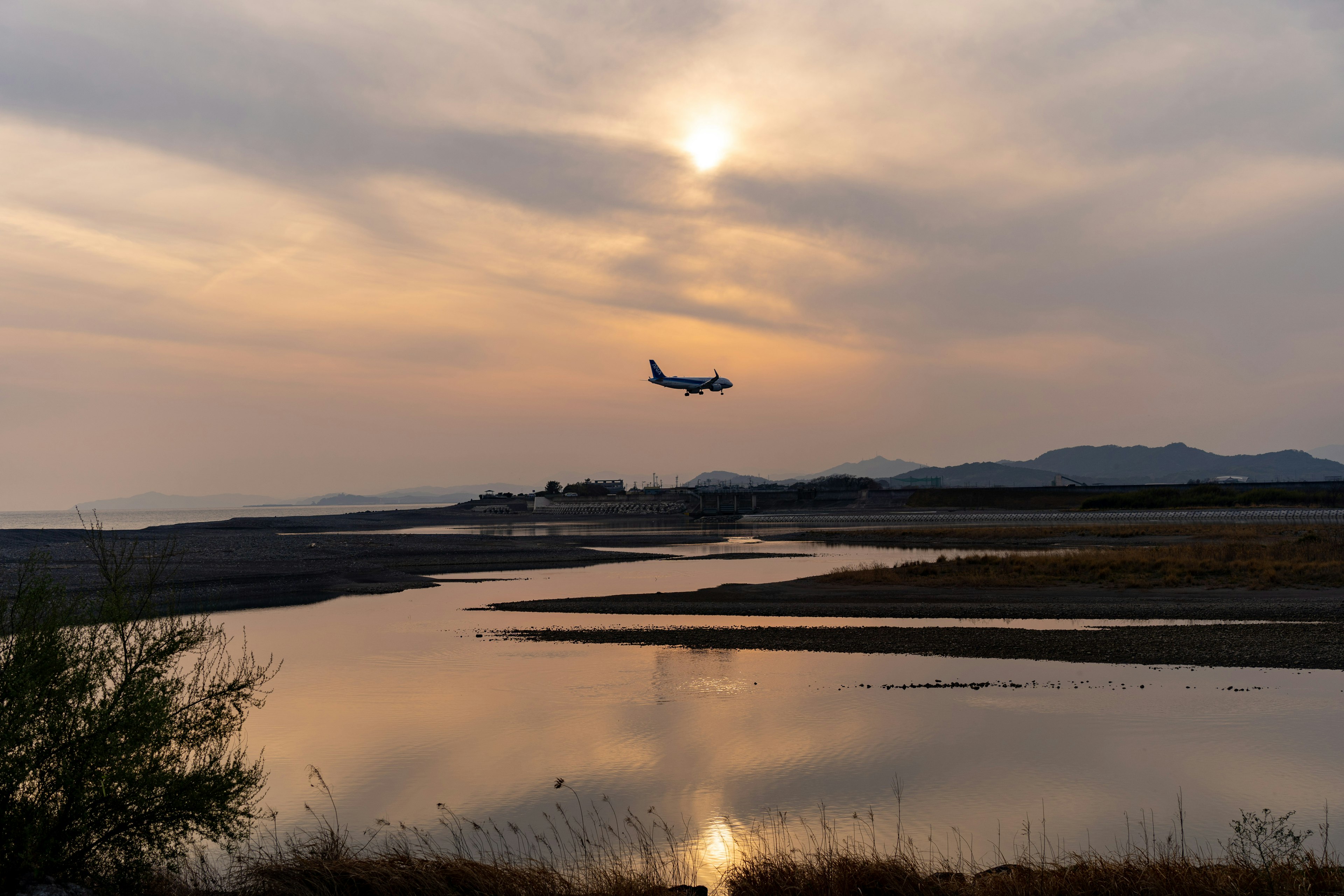 Un paisaje hermoso con un avión volando contra el atardecer