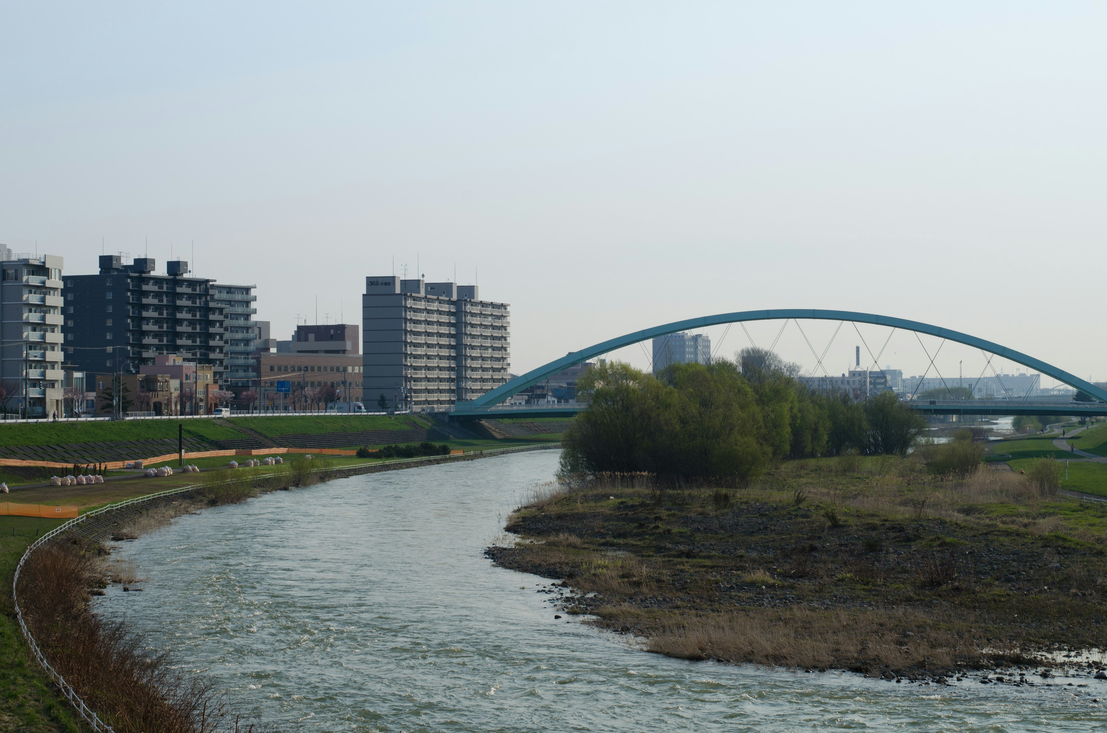 Ponte ad arco blu su un fiume calmo con edifici vicini