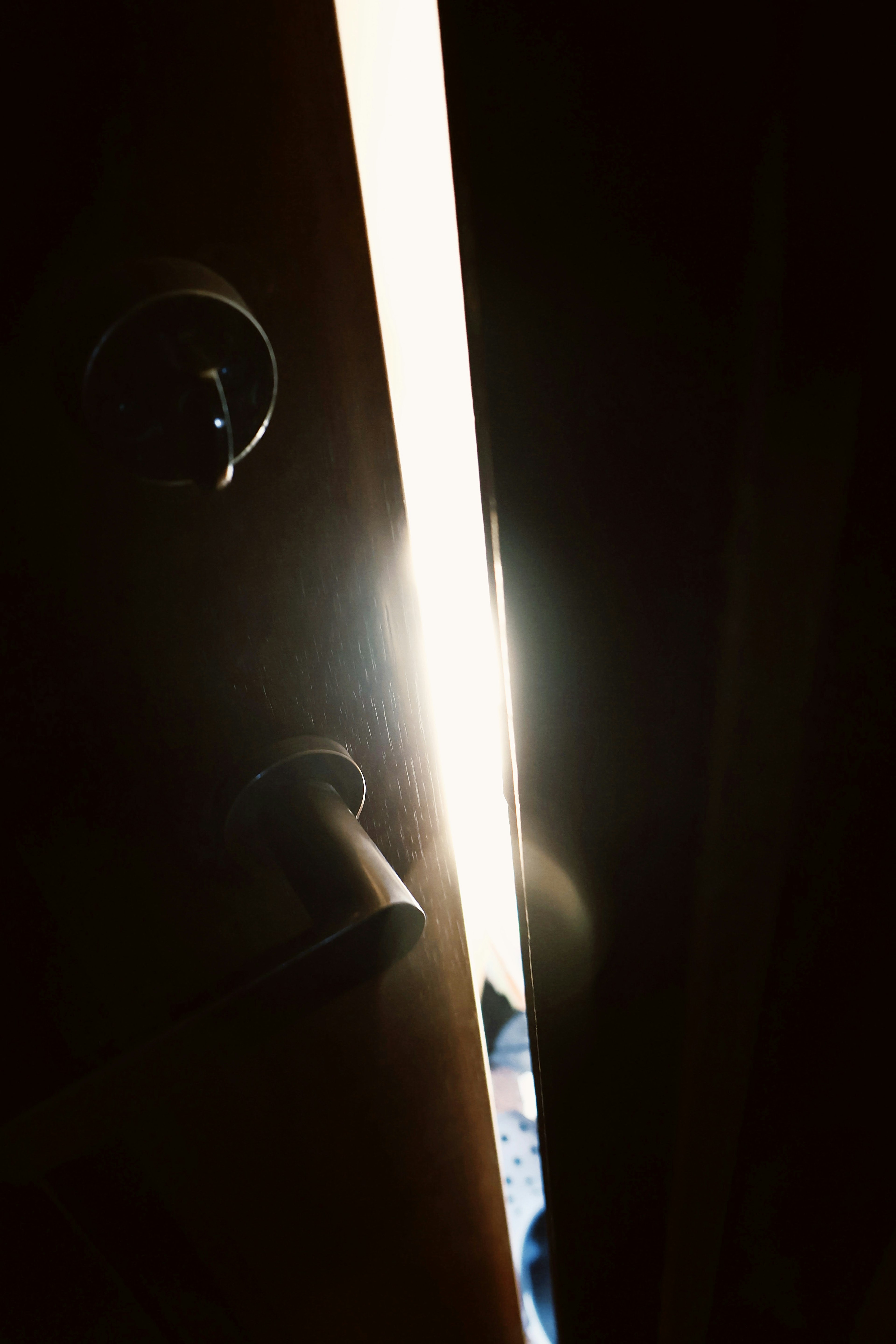 Image of light streaming through a crack in a door