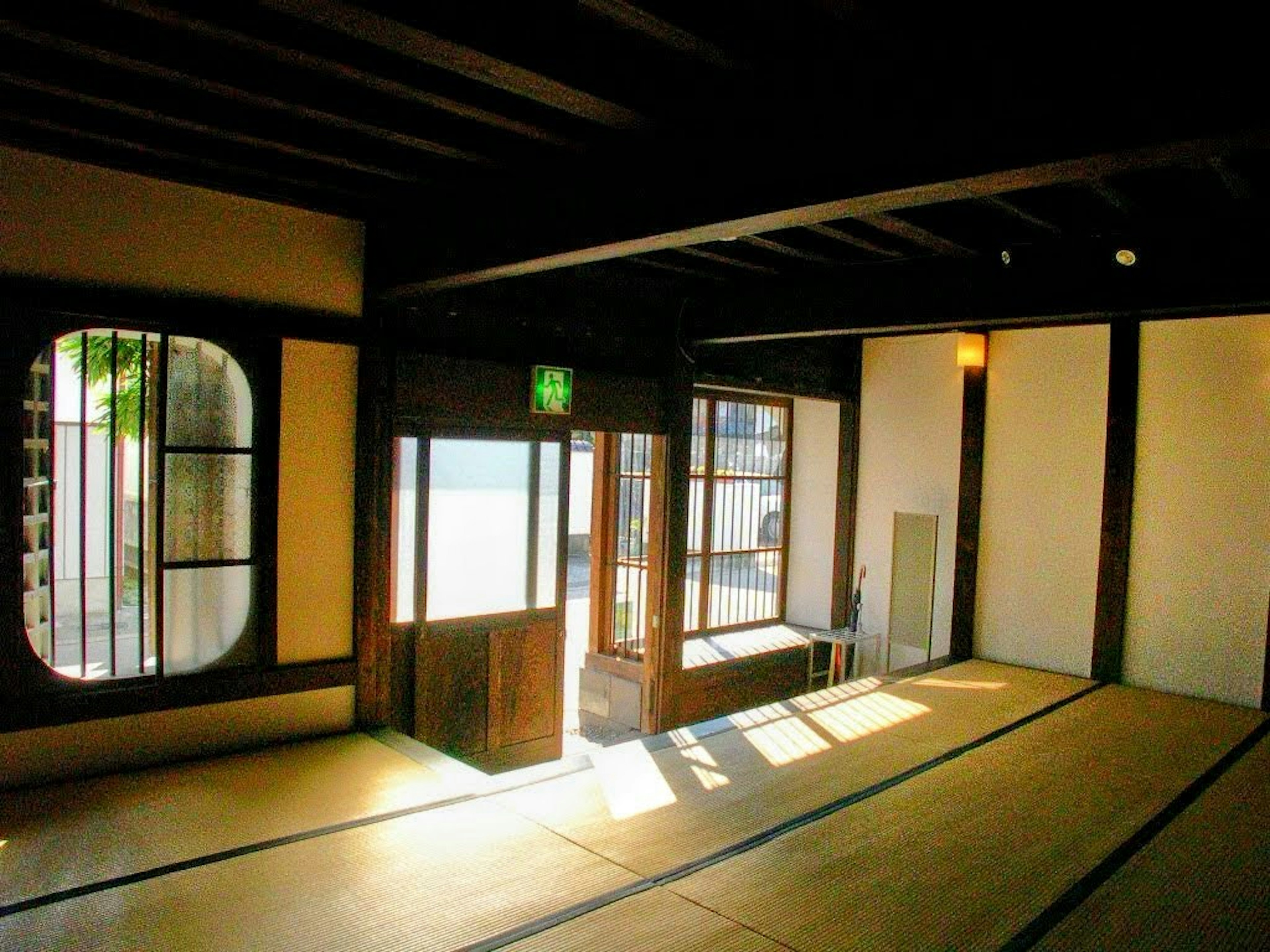 Bright interior of a Japanese room featuring wooden beams and tatami mats