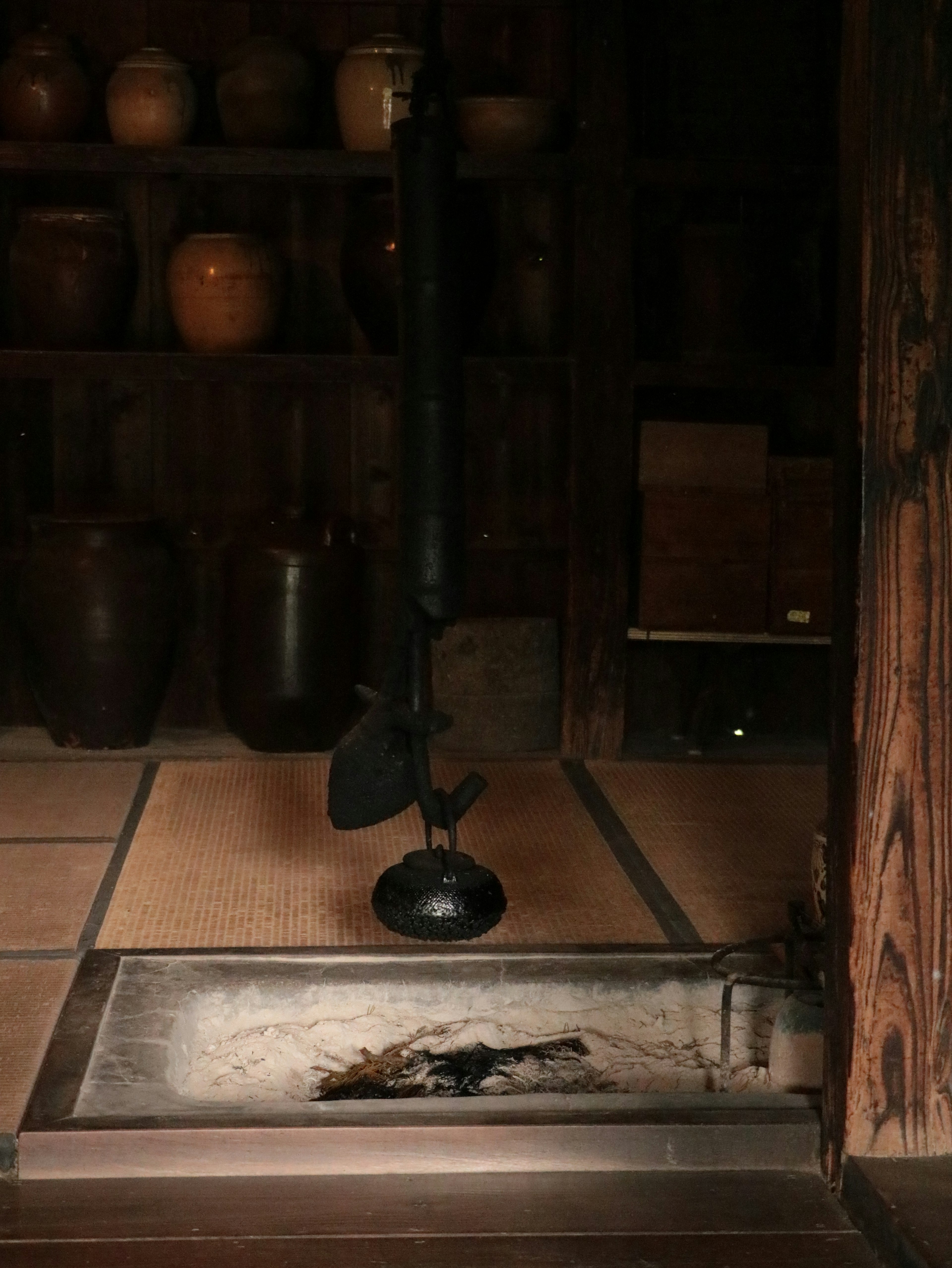 Traditional Japanese hearth with old pottery displayed on shelves