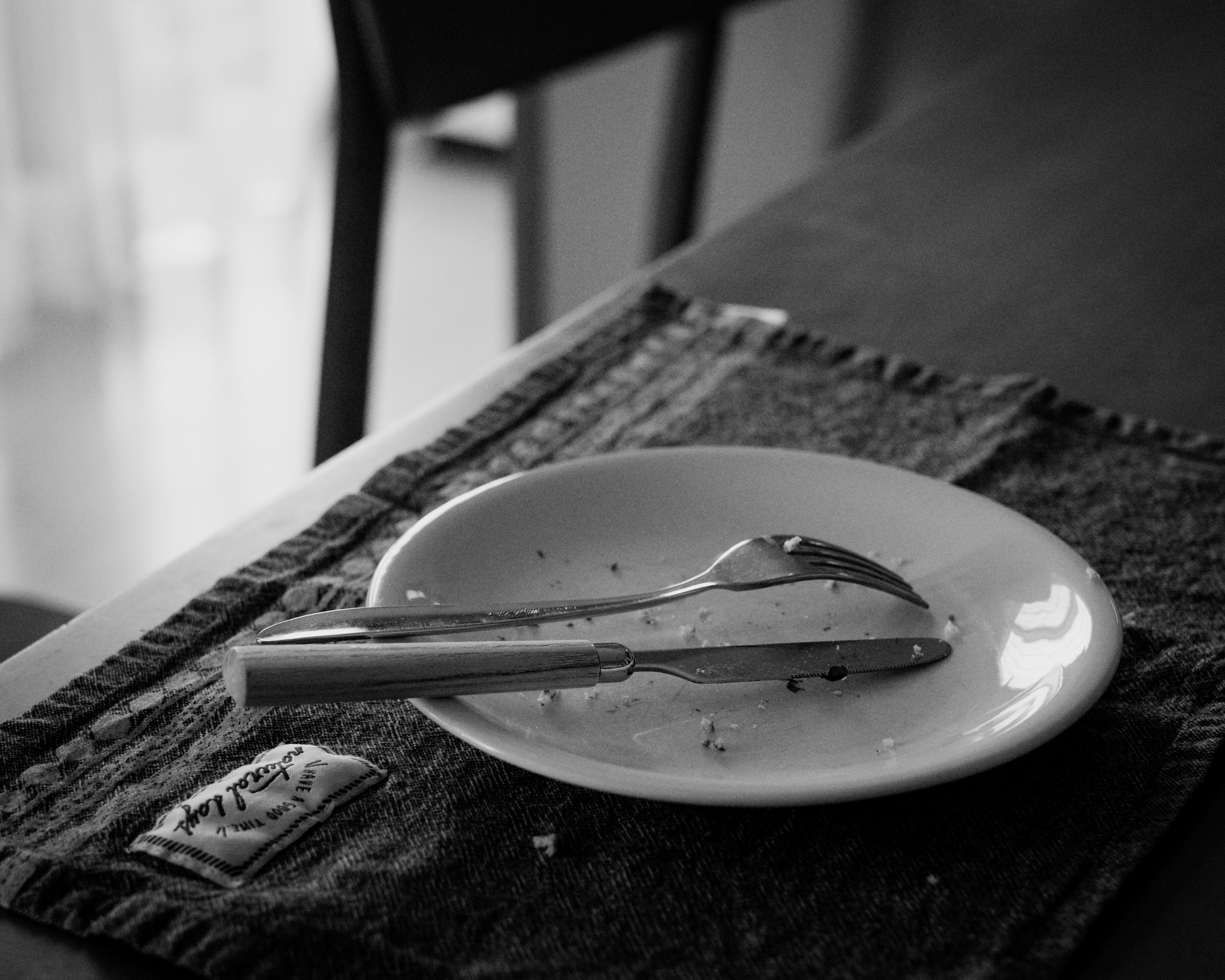 Black and white image of a plate and cutlery on a table