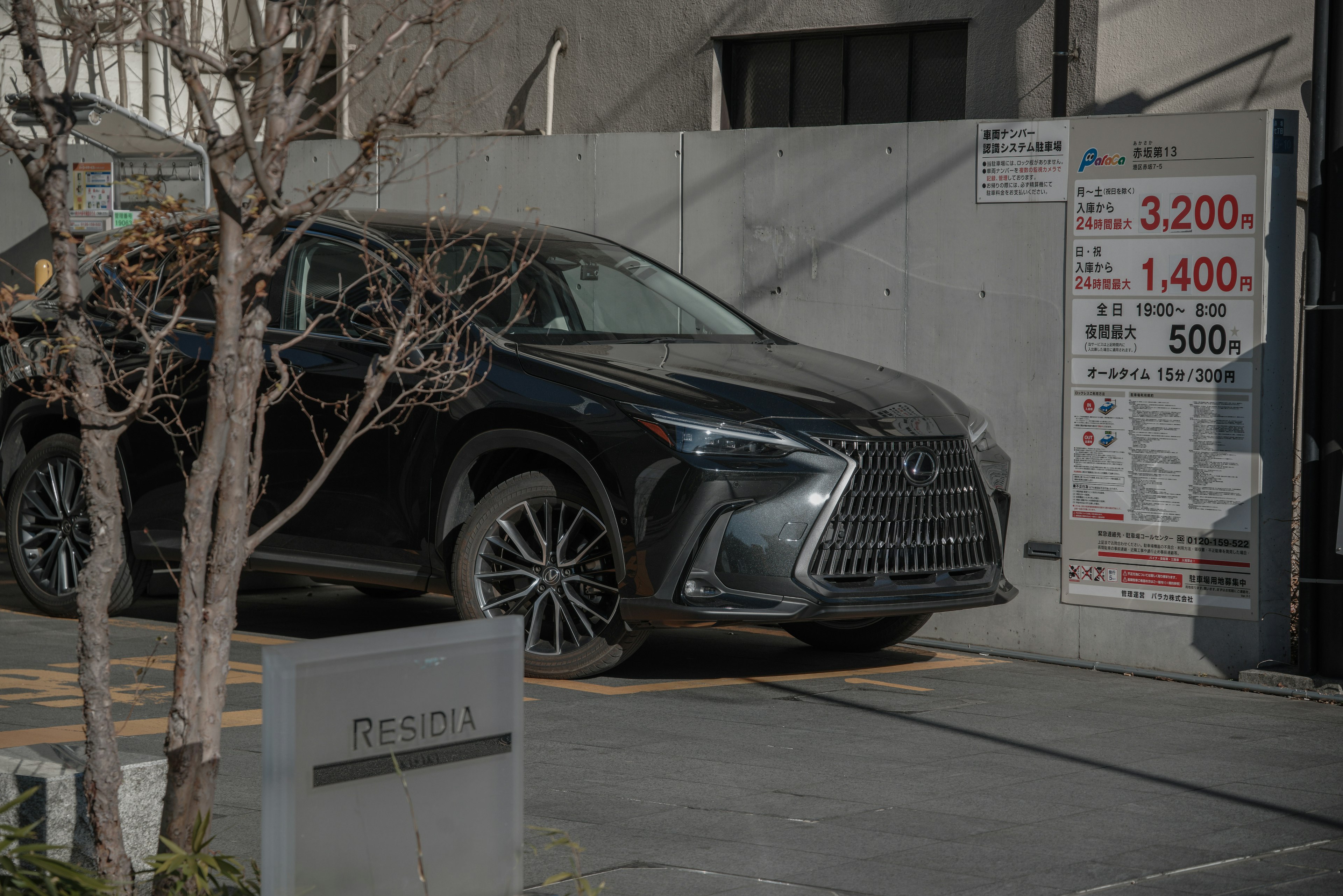 SUV สีดำ Lexus จอดอยู่ในสภาพแวดล้อมเมืองสมัยใหม่