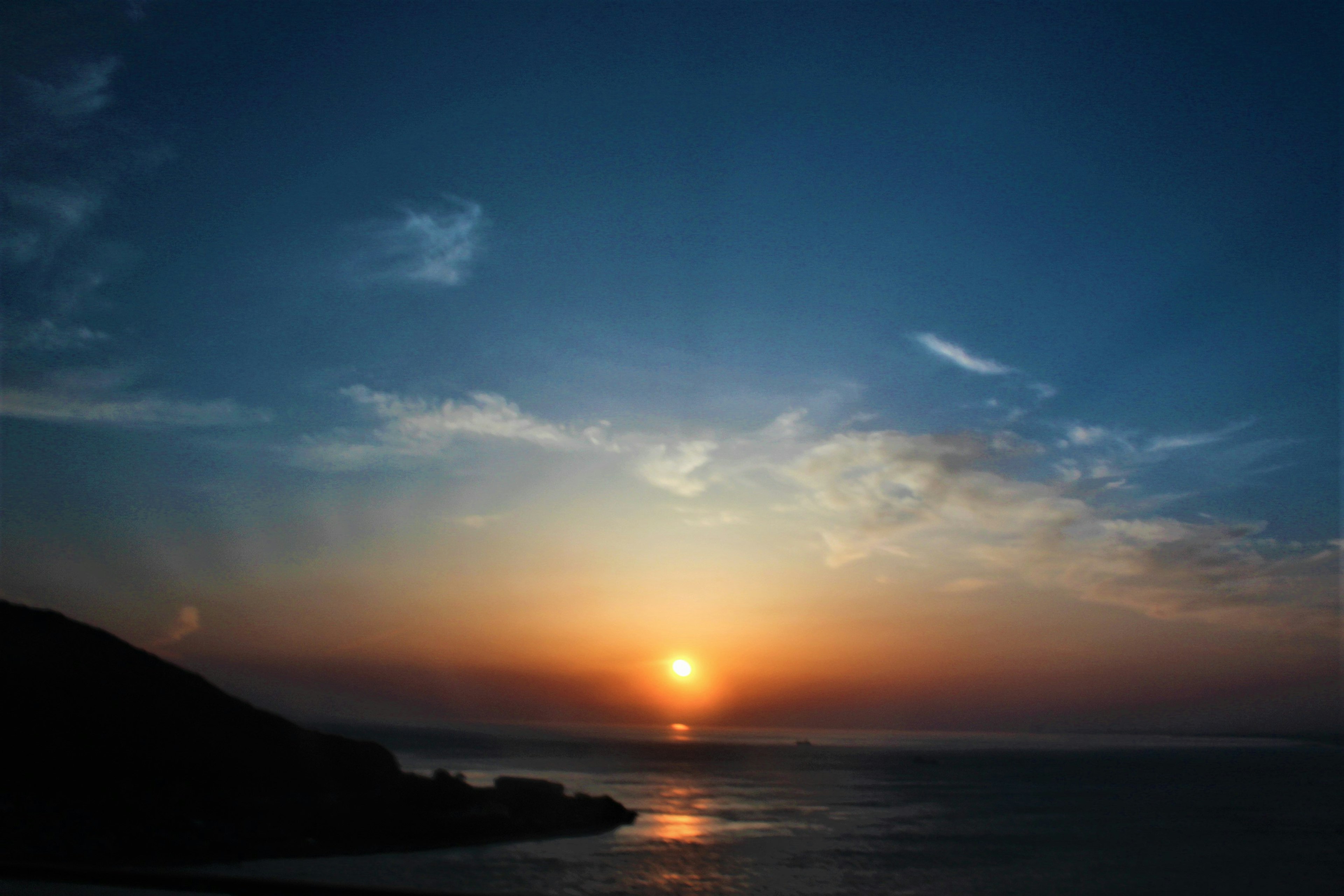 美しい夕日が海に沈む風景 青い空とオレンジ色の夕焼け