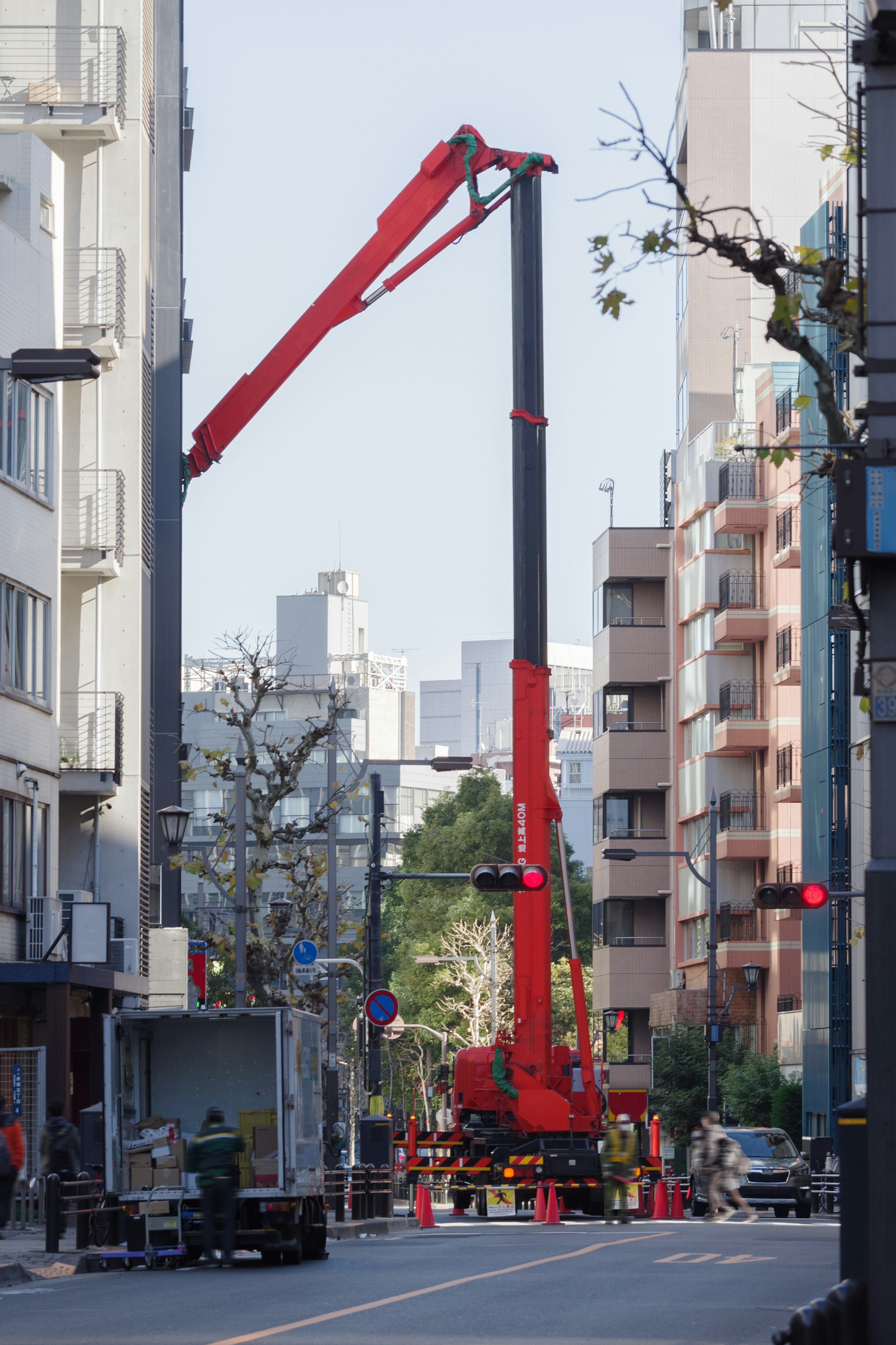 赤いクレーンが都市の通りで作業している様子