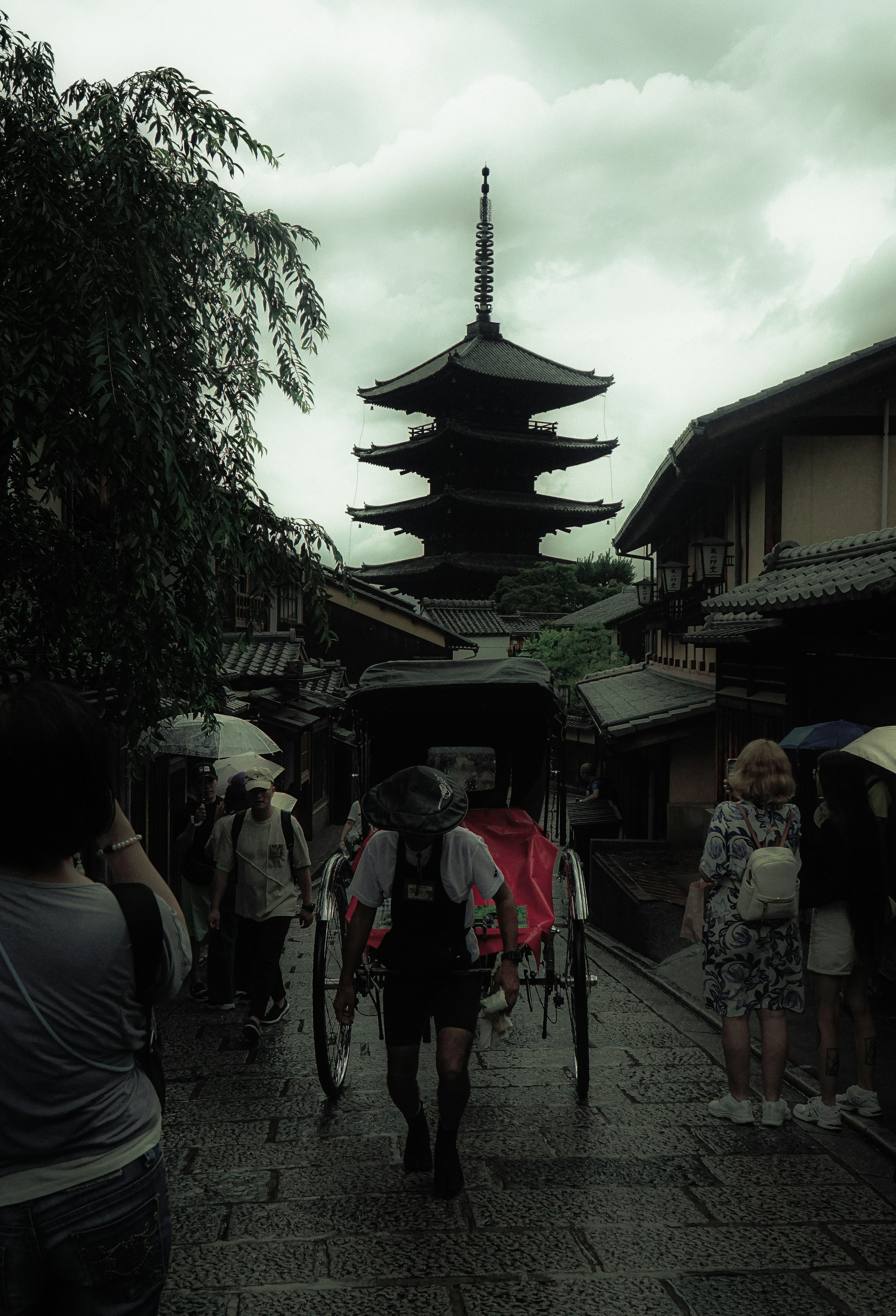 人力车穿过历史街道，背景是一座塔