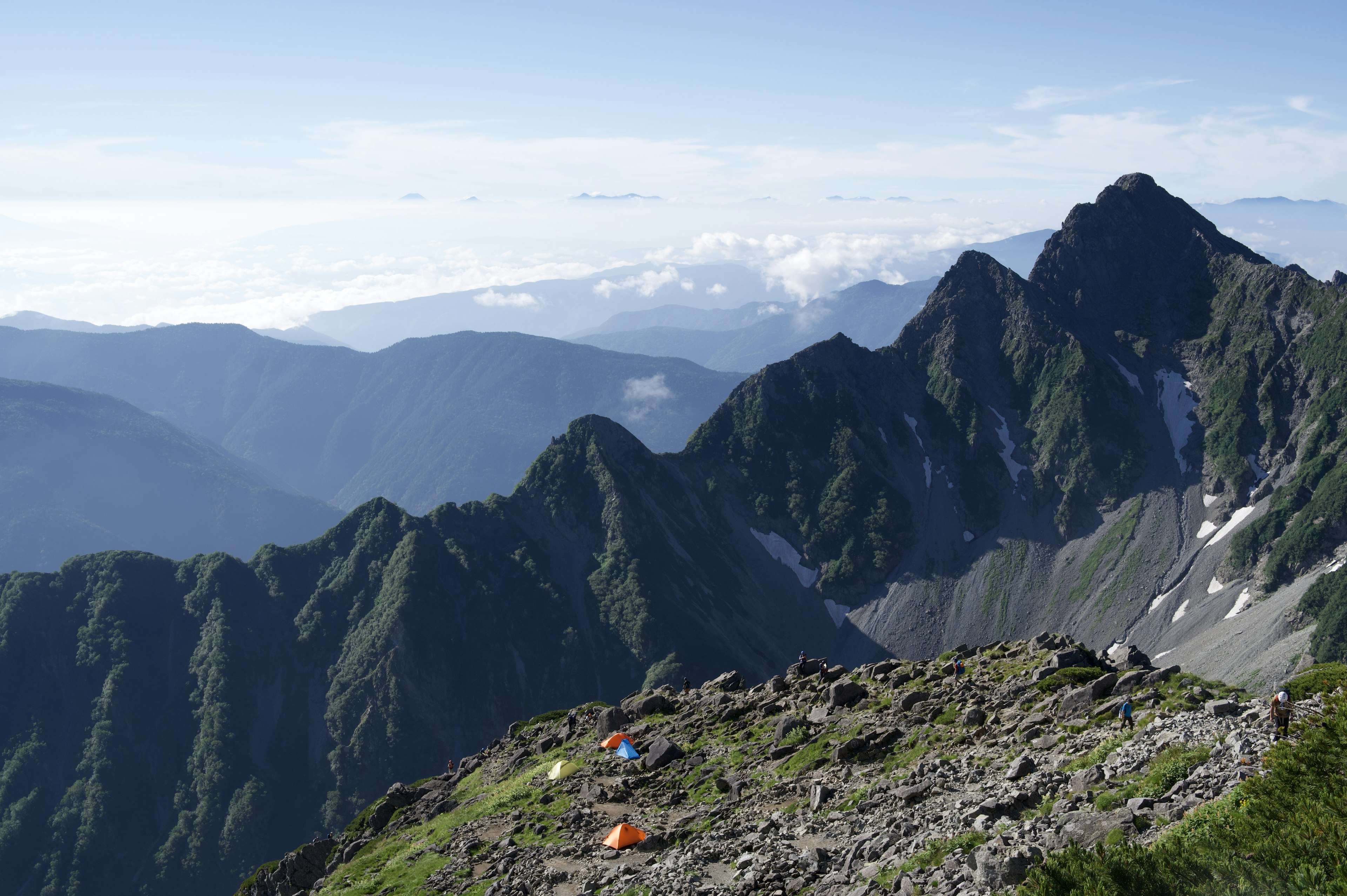 Malersiche Aussicht auf Berge und blauen Himmel mit sichtbaren Zelten