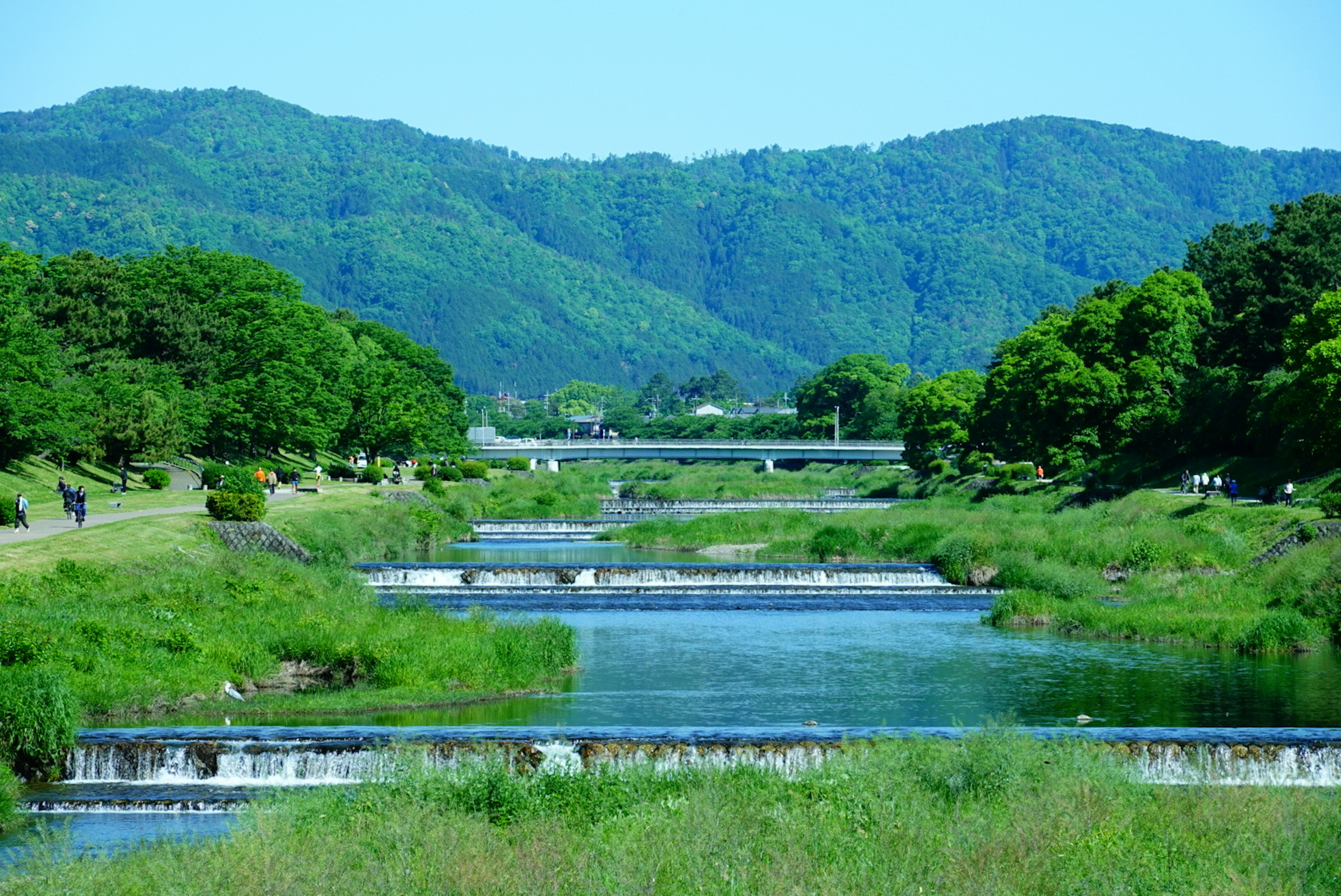 Pemandangan indah sungai biru dikelilingi oleh pegunungan hijau