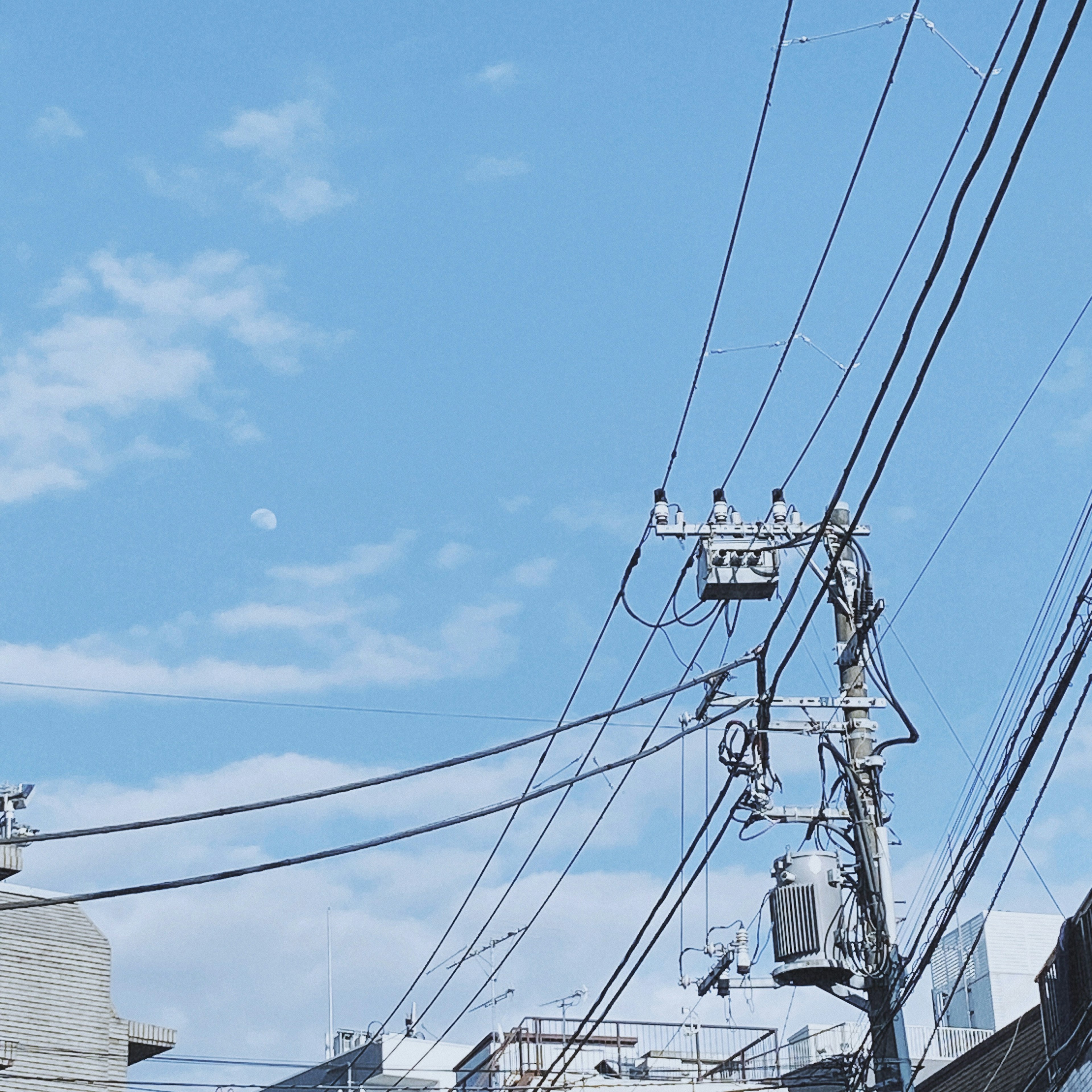 Urban scene with blue sky and intersecting power lines