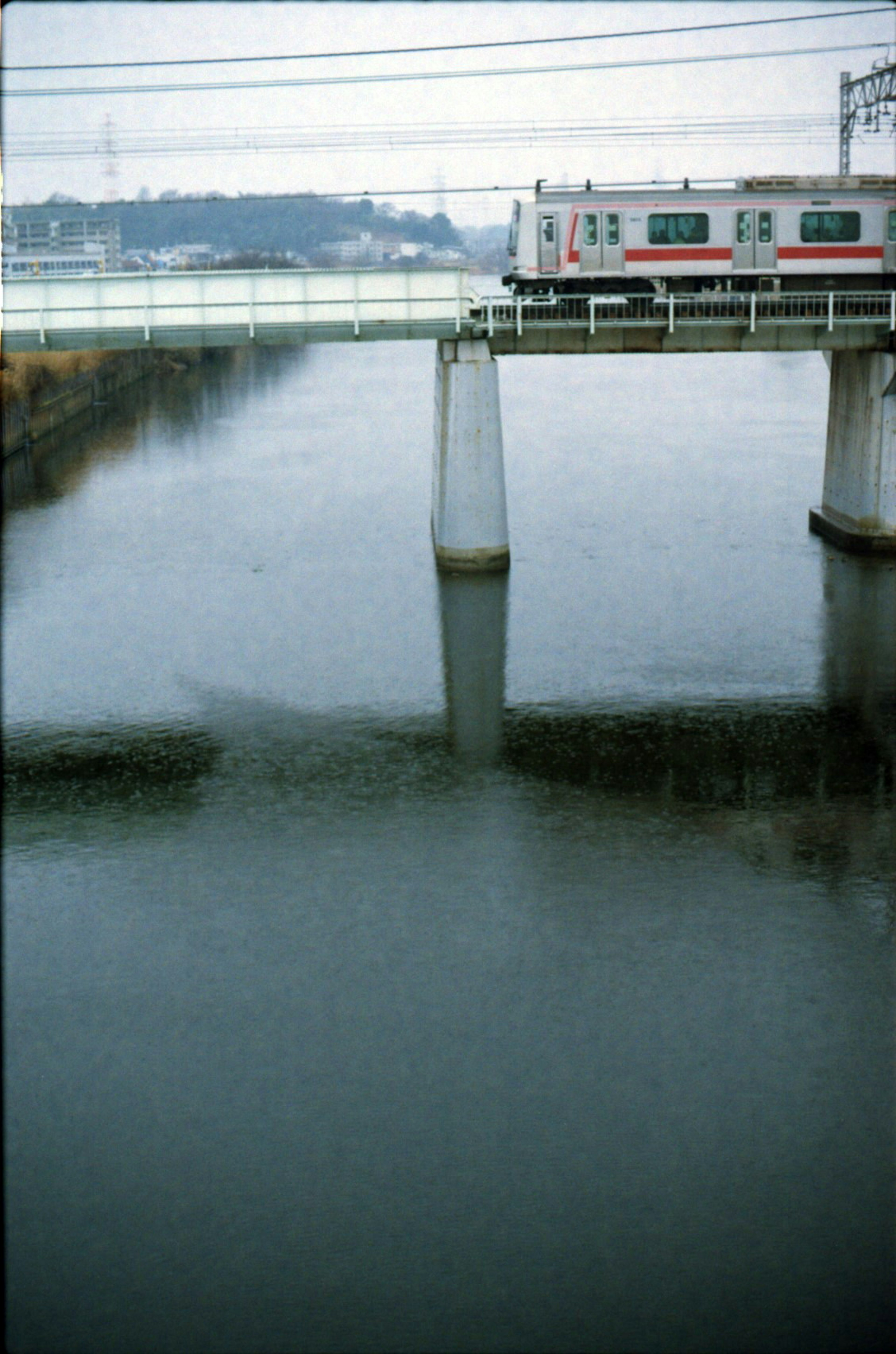 Tren cruzando un río con reflejos en el agua