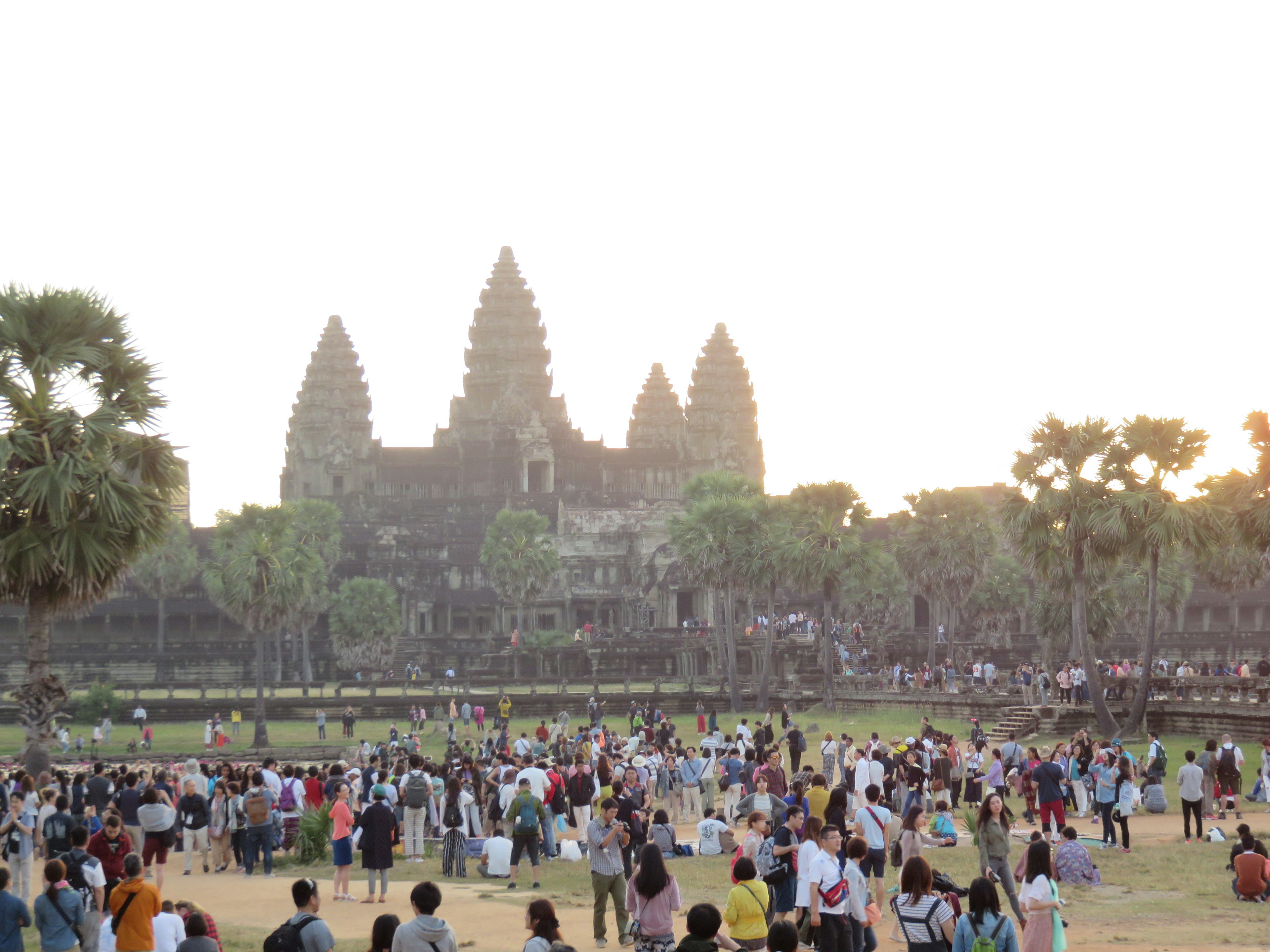 Sunset view of Angkor Wat with large crowd of tourists