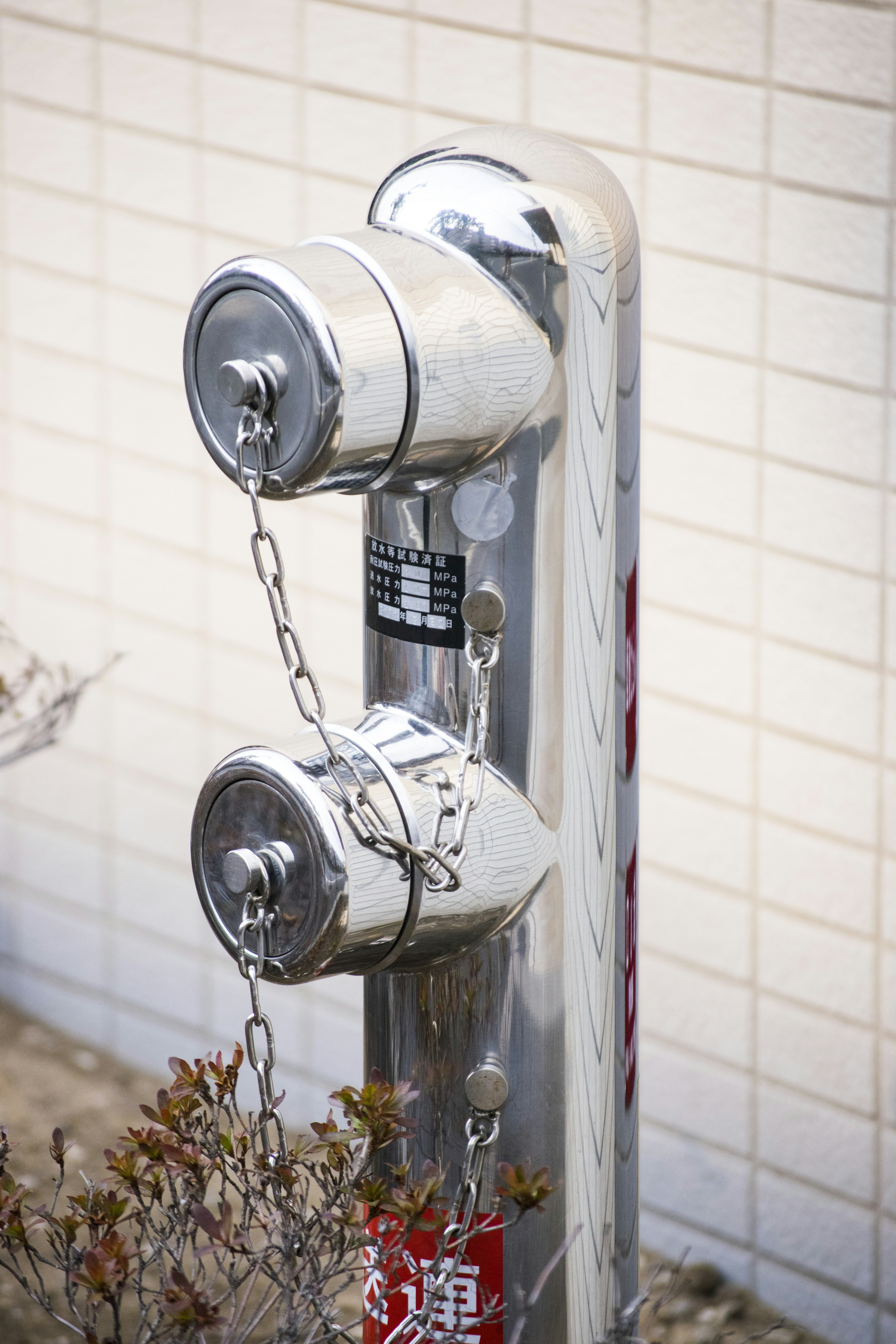 Metal fire hydrant standing in front of a wall