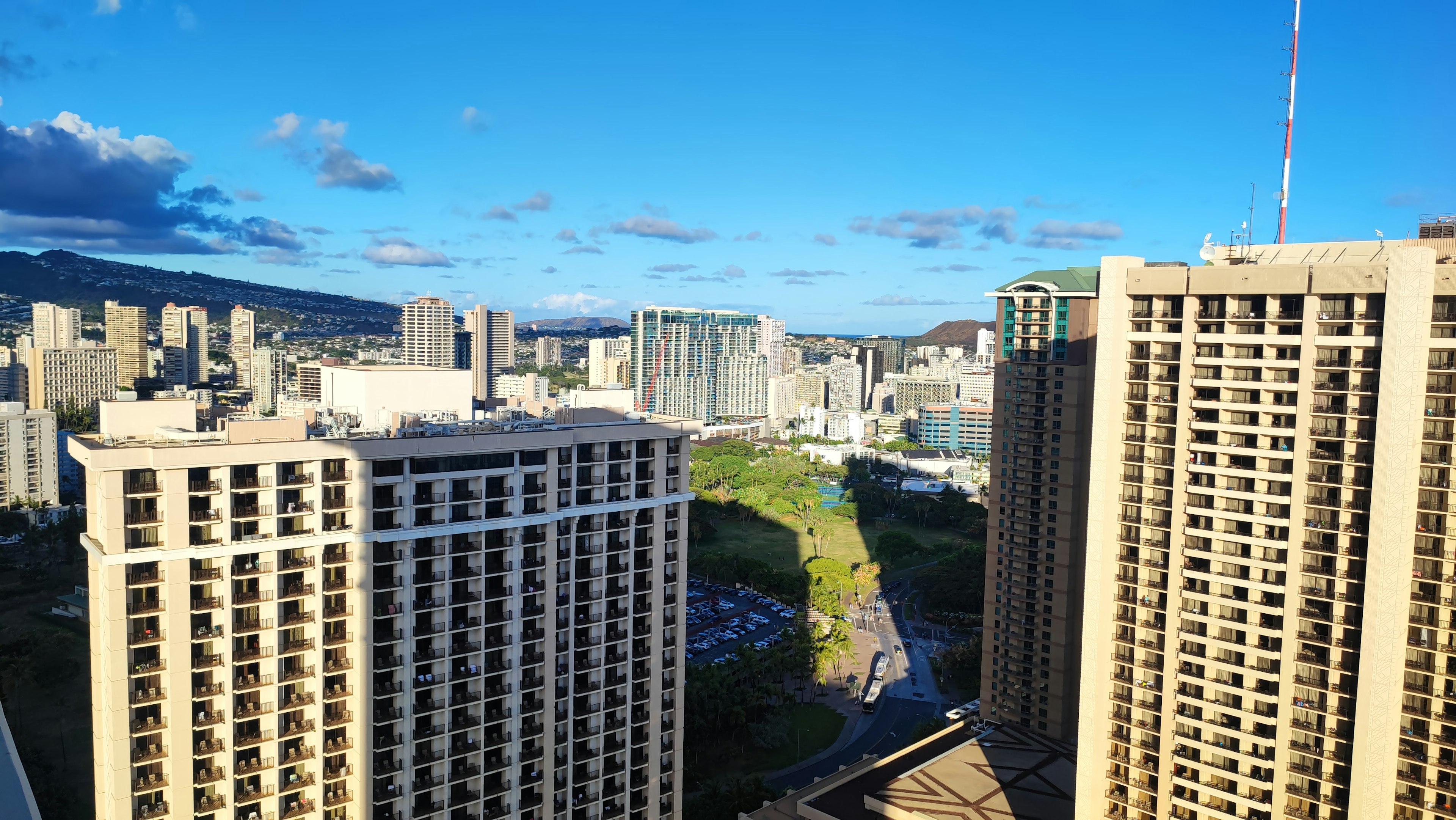 Cityscape of Hawaii viewed from a high-rise building with blue sky and clouds