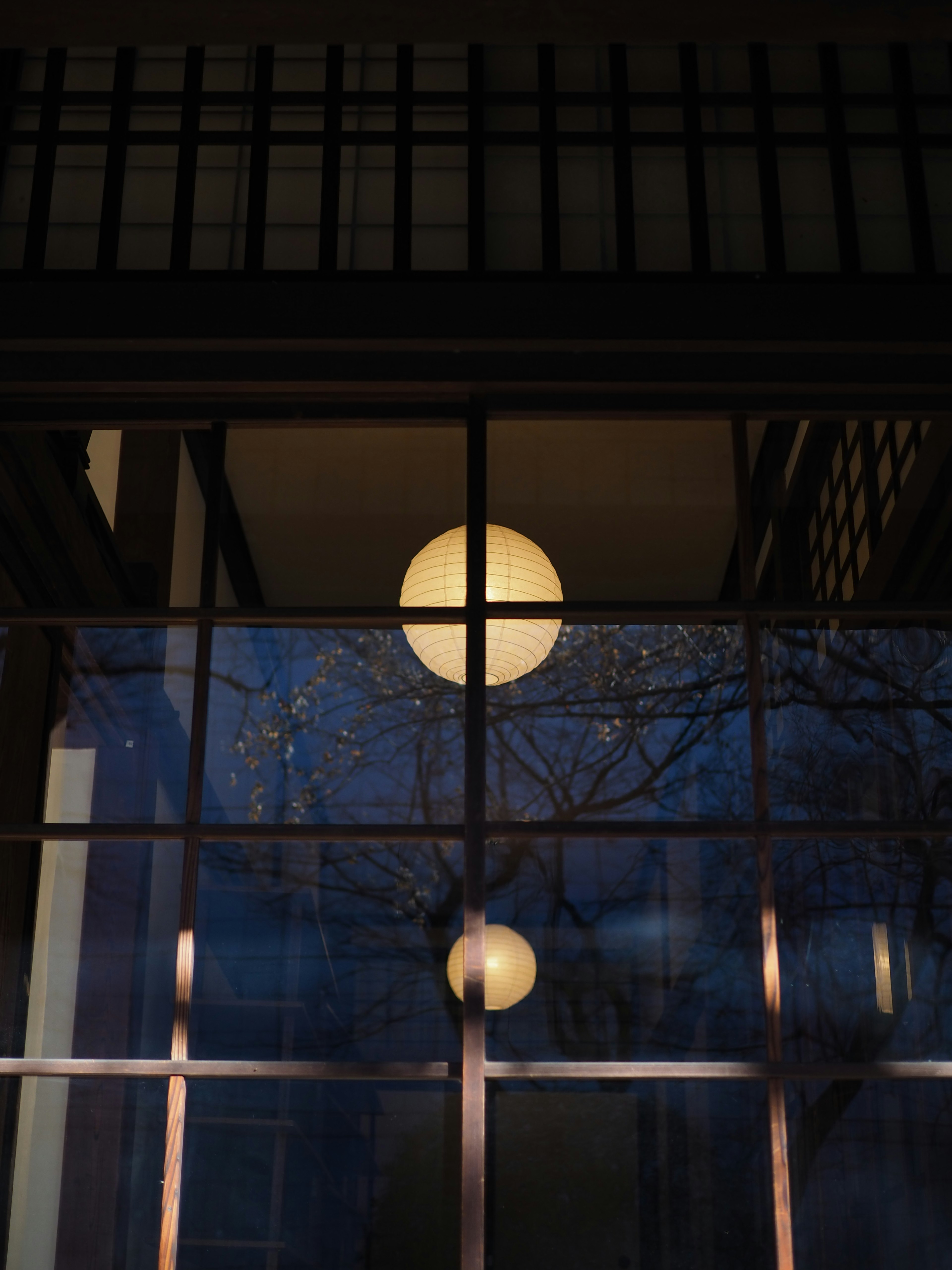 Japanese lanterns visible through a window with a blue background