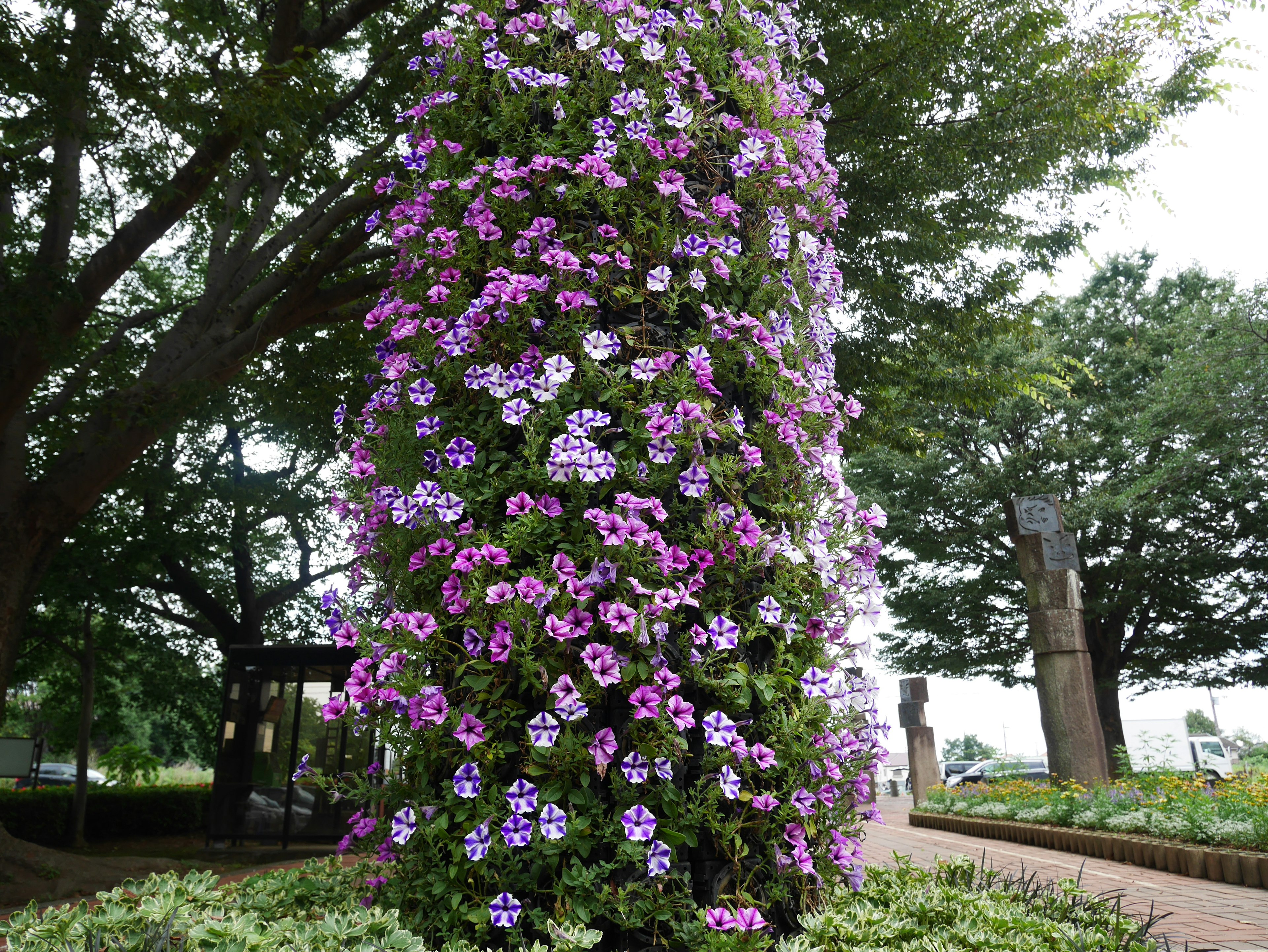 色とりどりの花が咲き誇る柱状の植物が見える美しい公園の風景