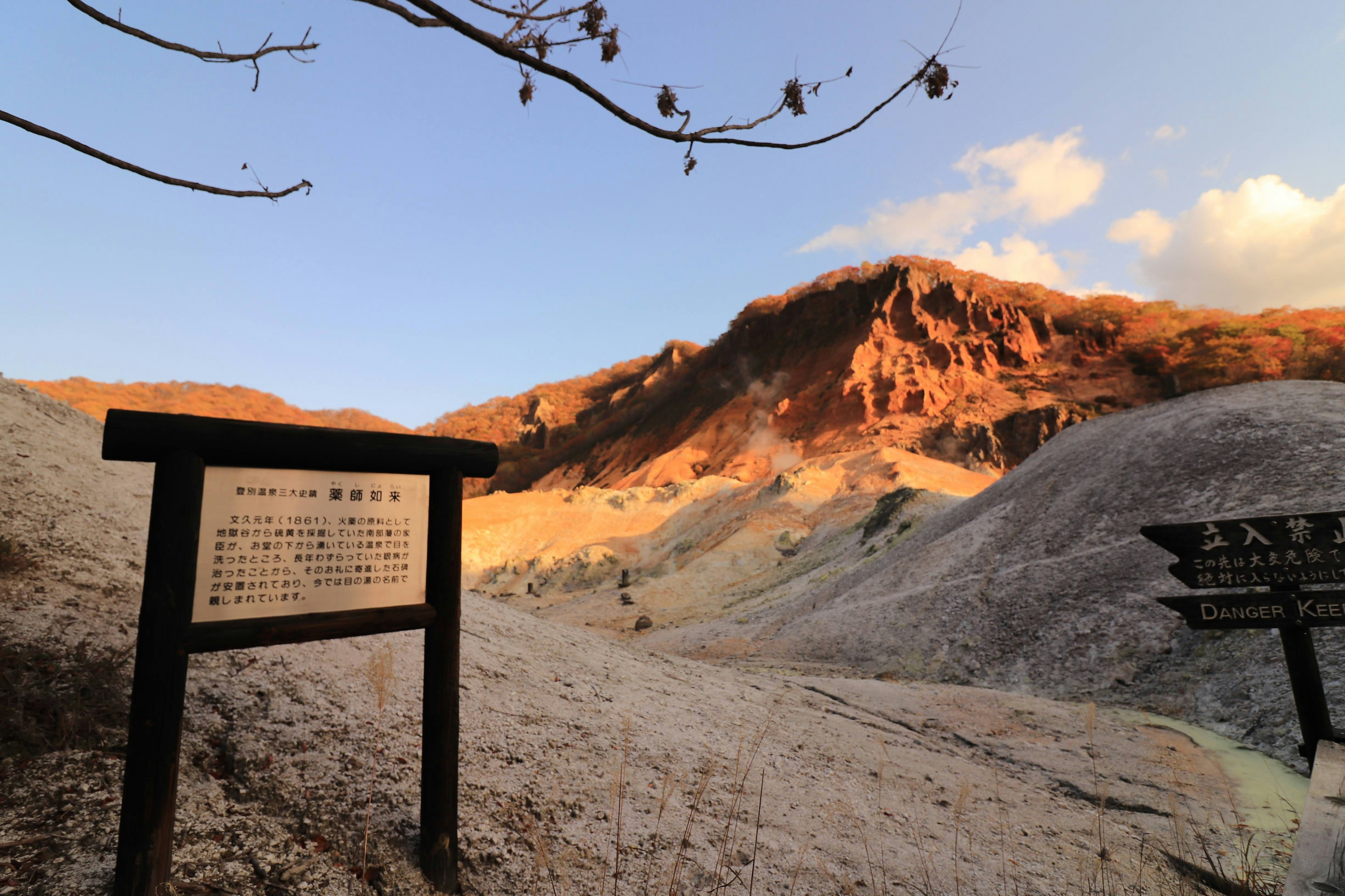 Vista escénica de montañas iluminadas por el atardecer con un letrero