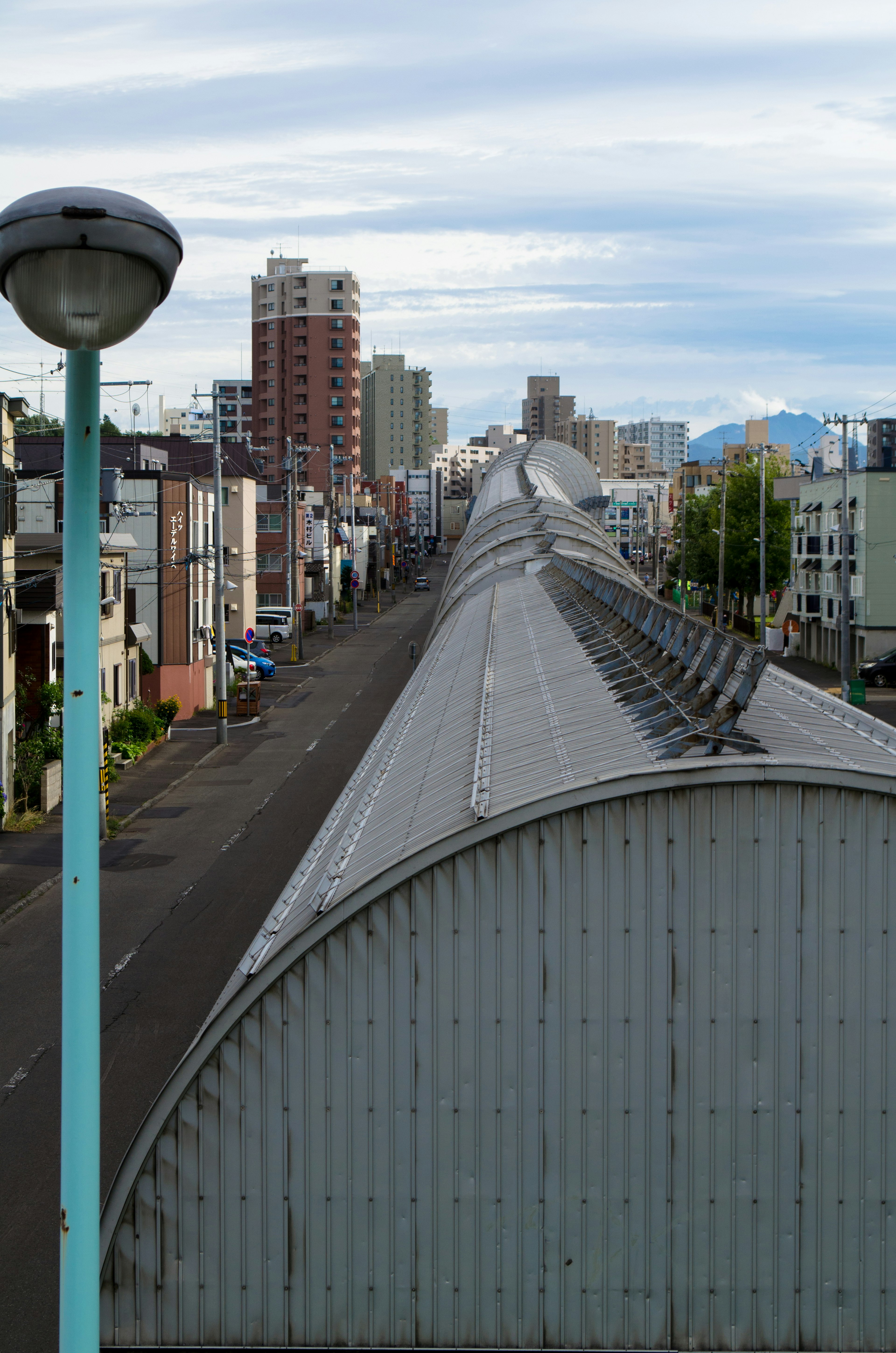 Vue d'une rue longue avec un toit et des bâtiments en arrière-plan