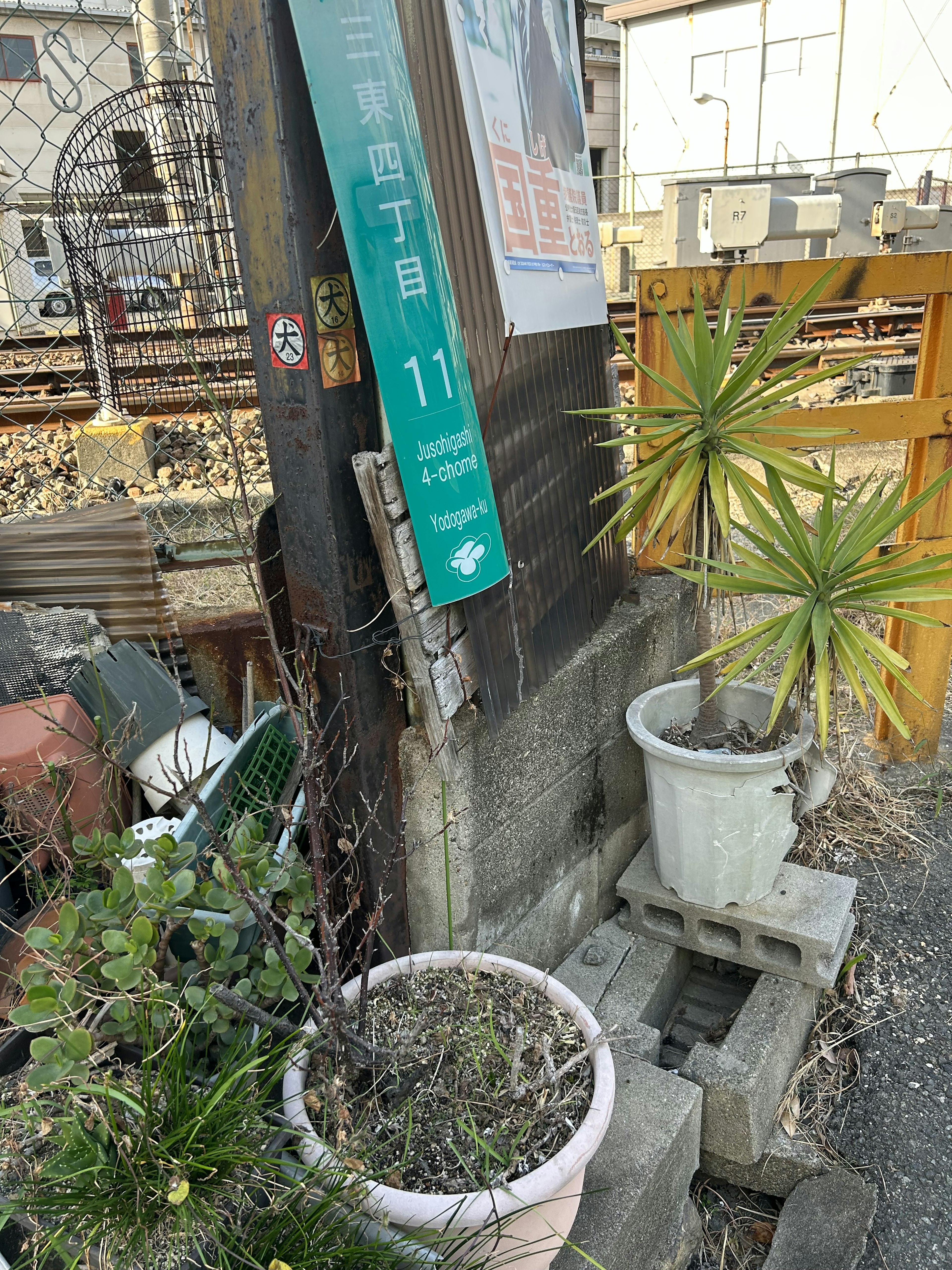 A street sign with the number 11 next to potted plants