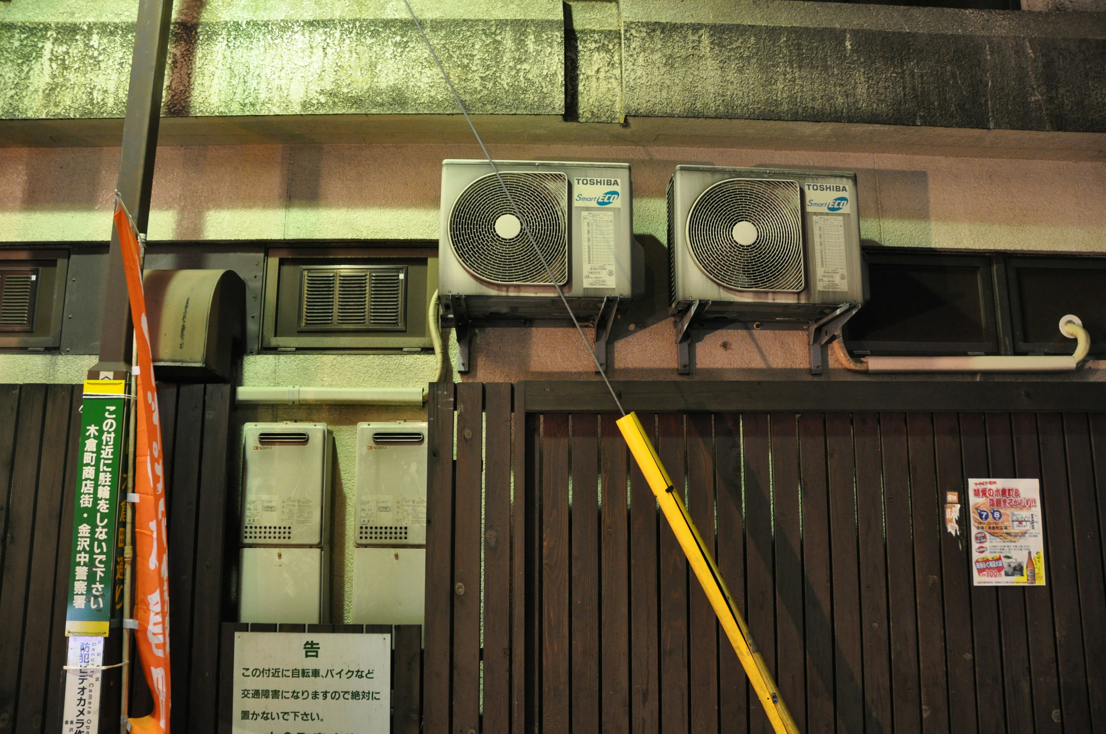 Night scene featuring two air conditioning units mounted on a wall