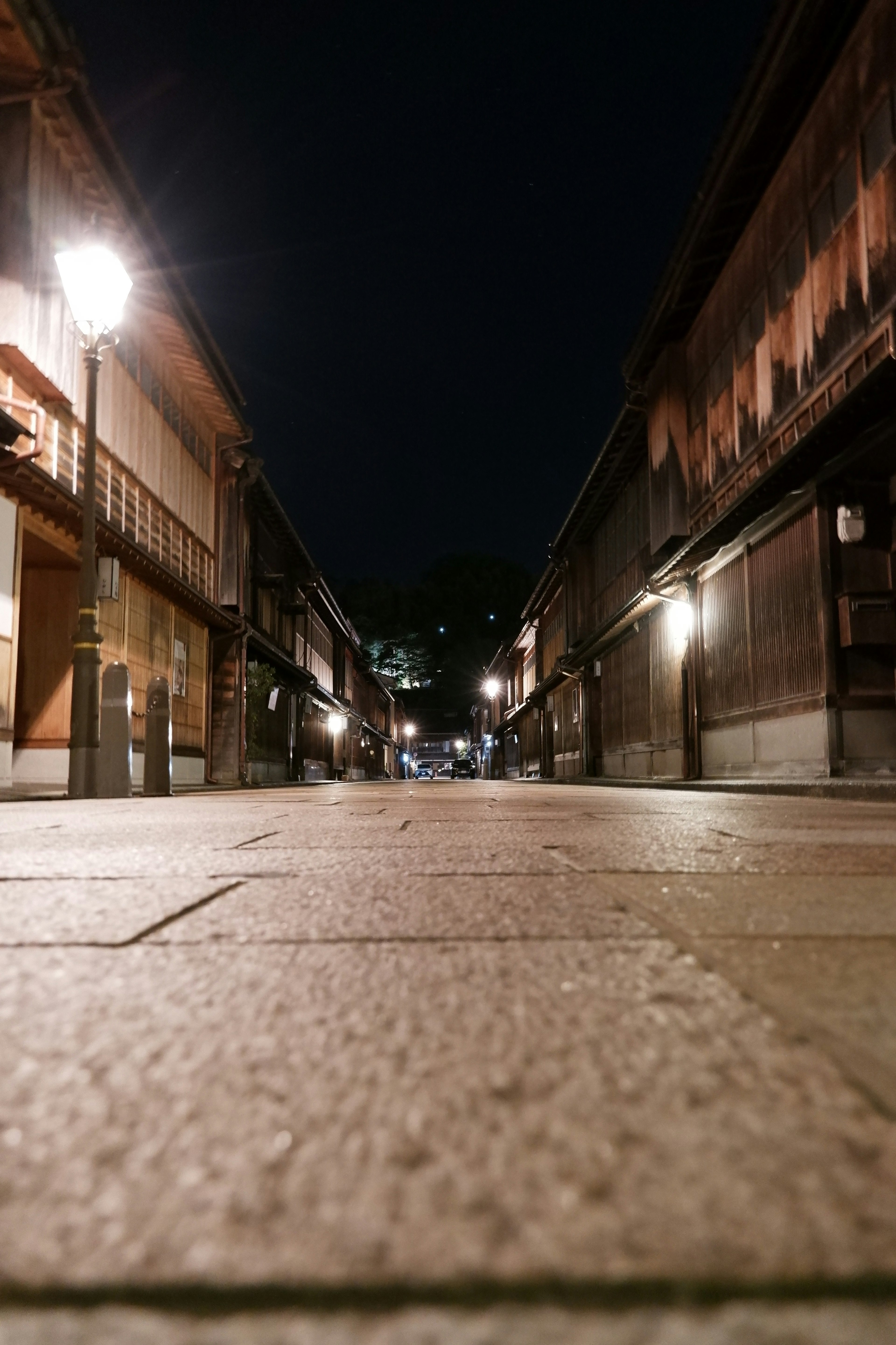 Quiet street view at night traditional buildings illuminated by street lamps