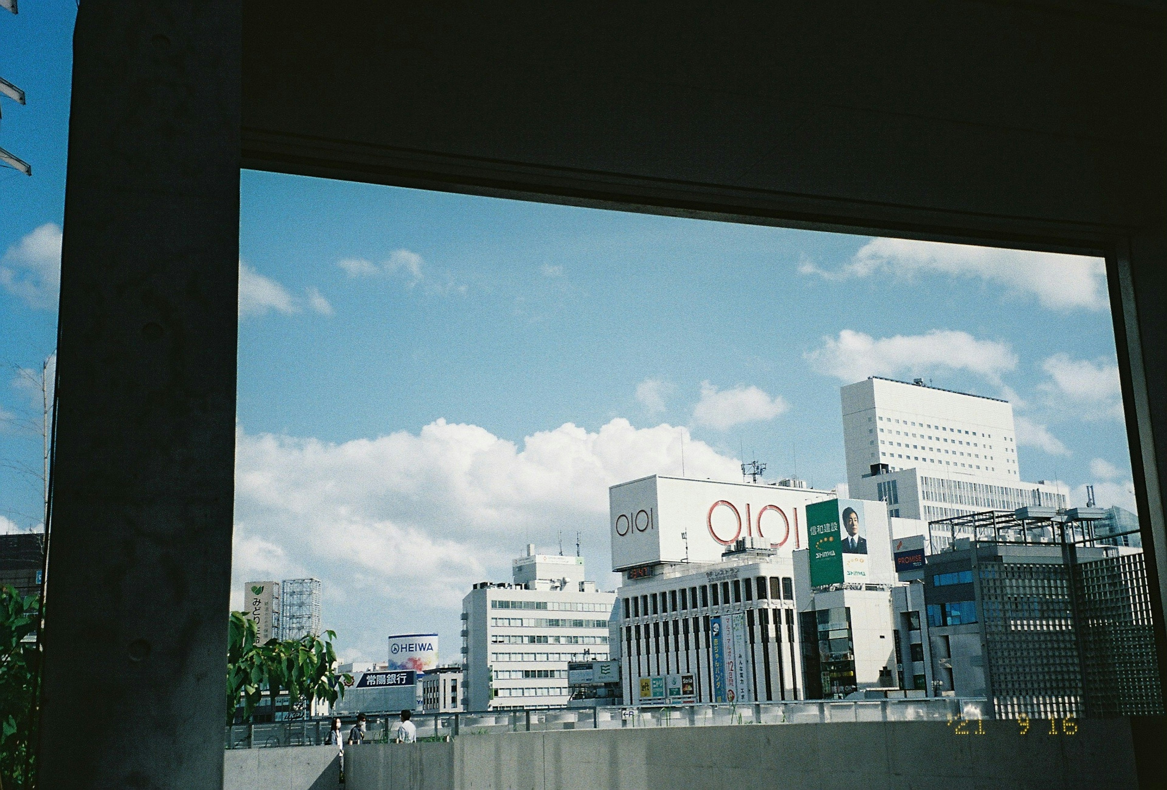 Urban landscape with blue sky and clouds featuring buildings and signs