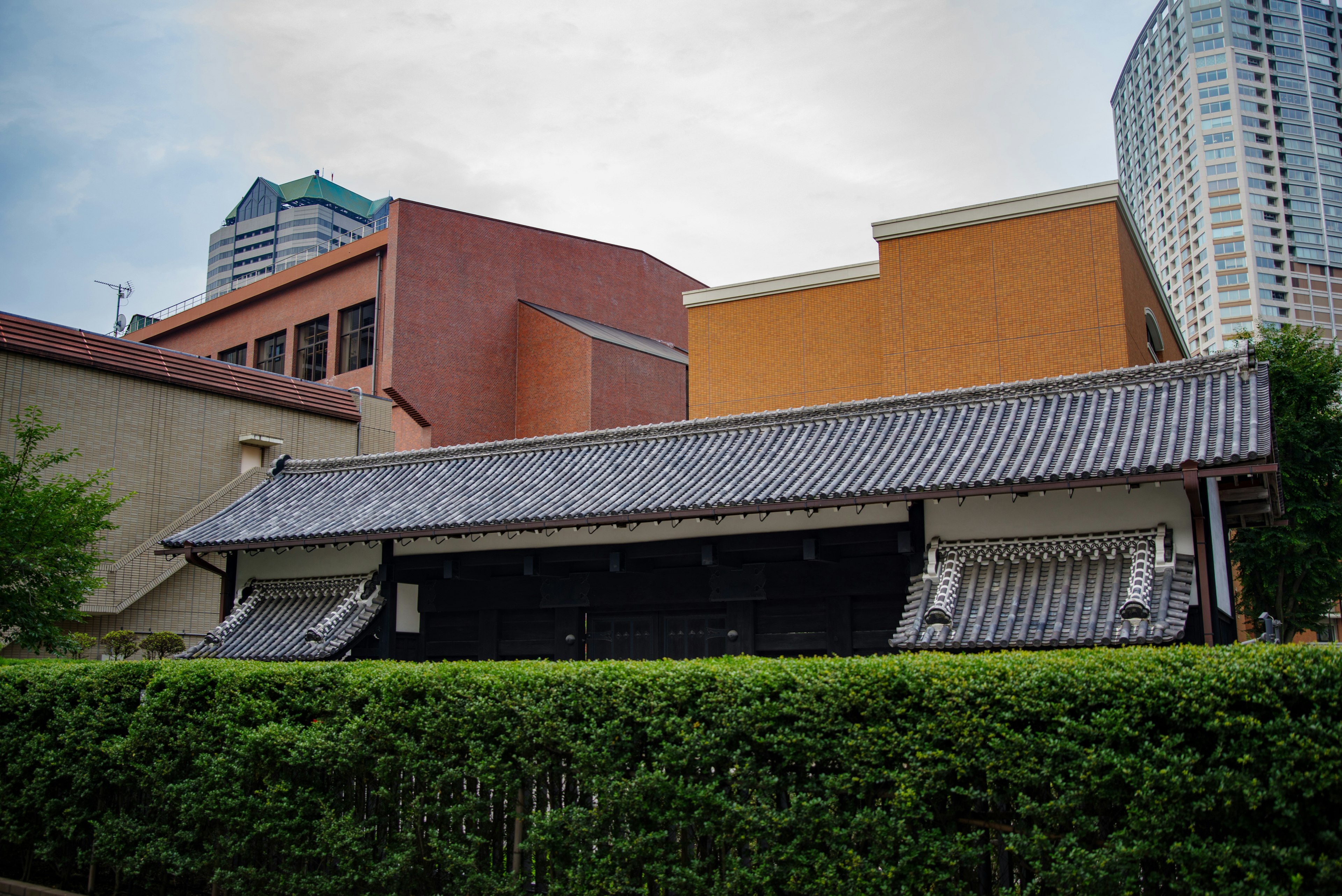 Fachada de una casa japonesa tradicional con edificios modernos al fondo