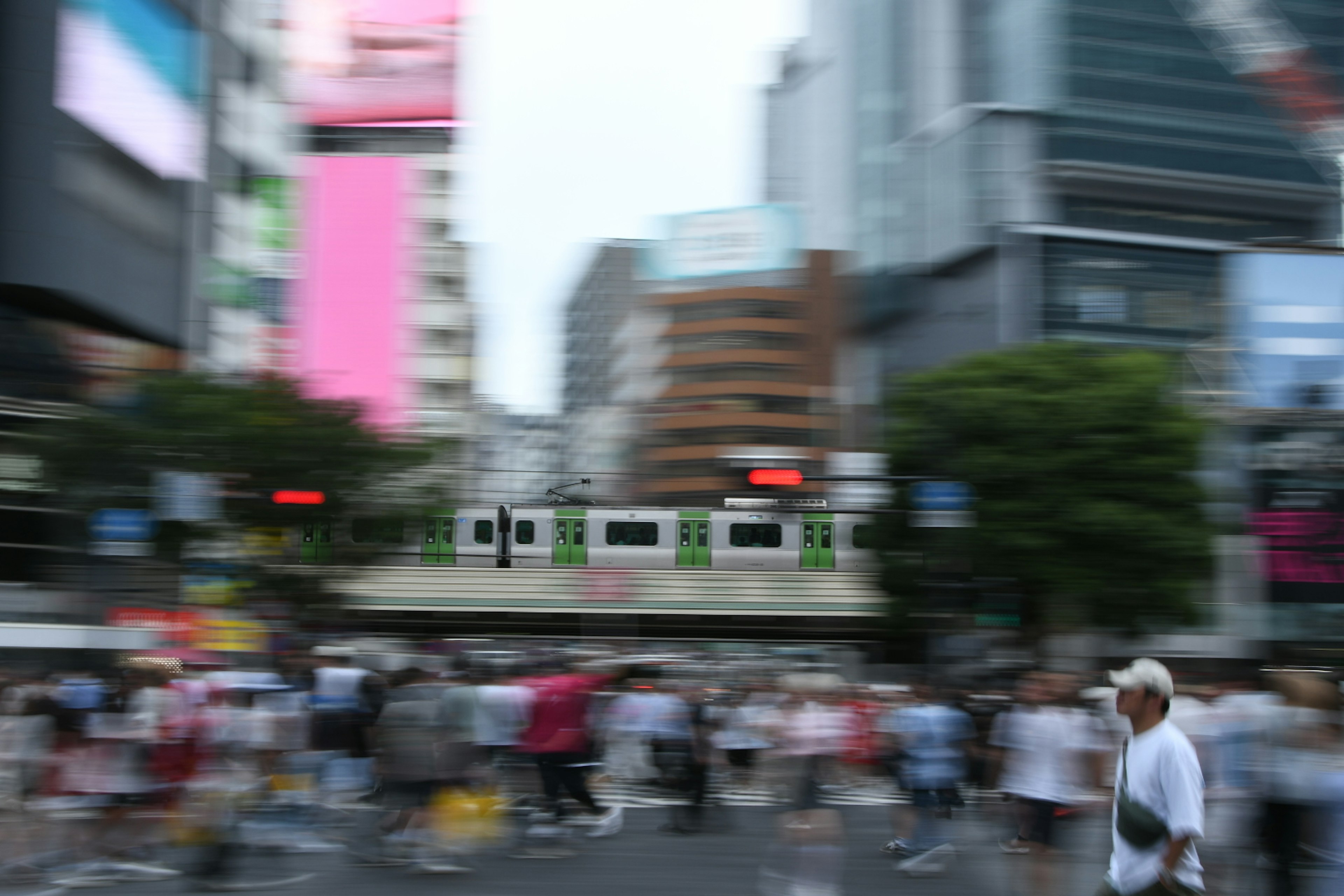 Busy intersection with pedestrians and city buildings in the background