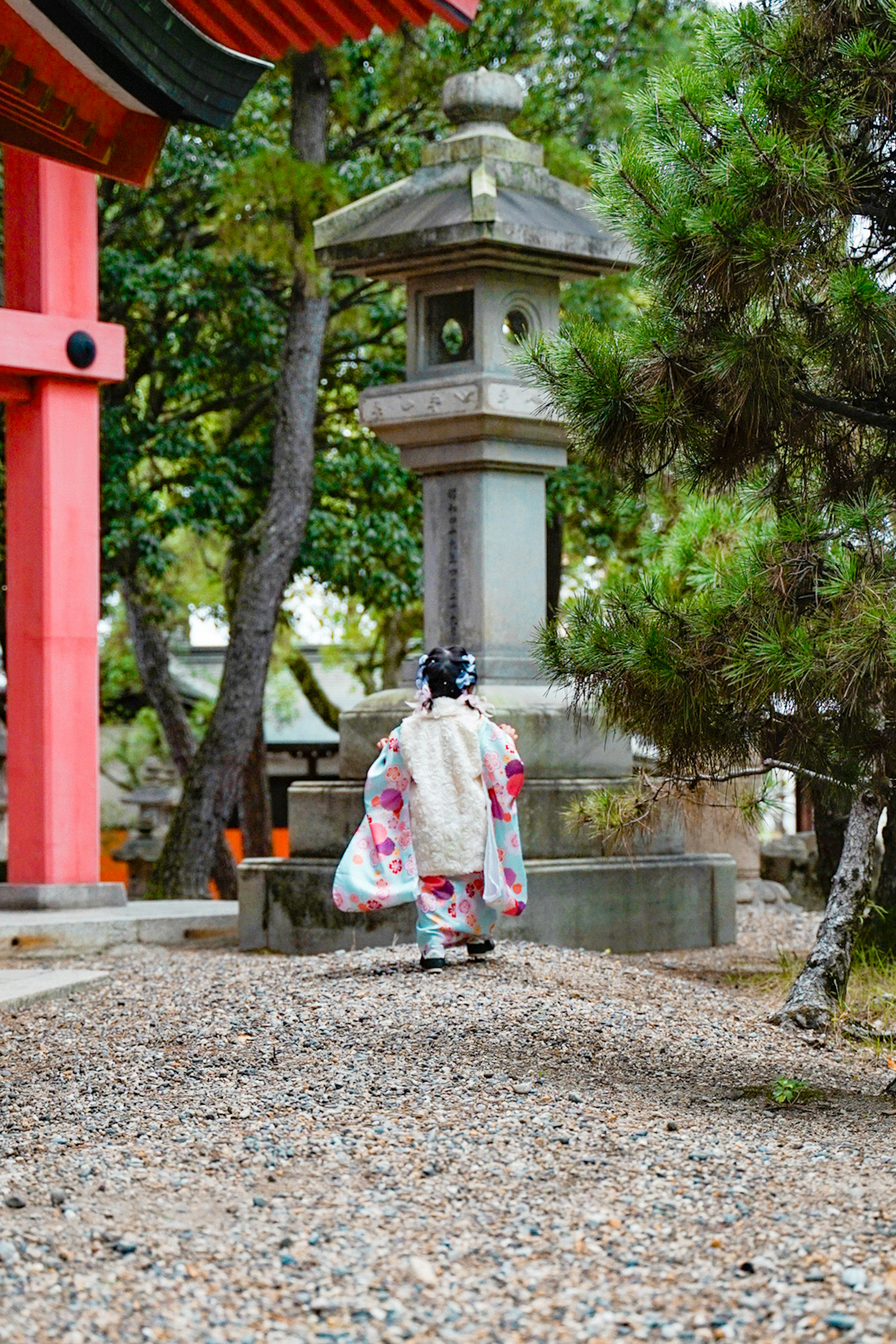 Un bambino in kimono tradizionale che cammina nel cortile di un santuario