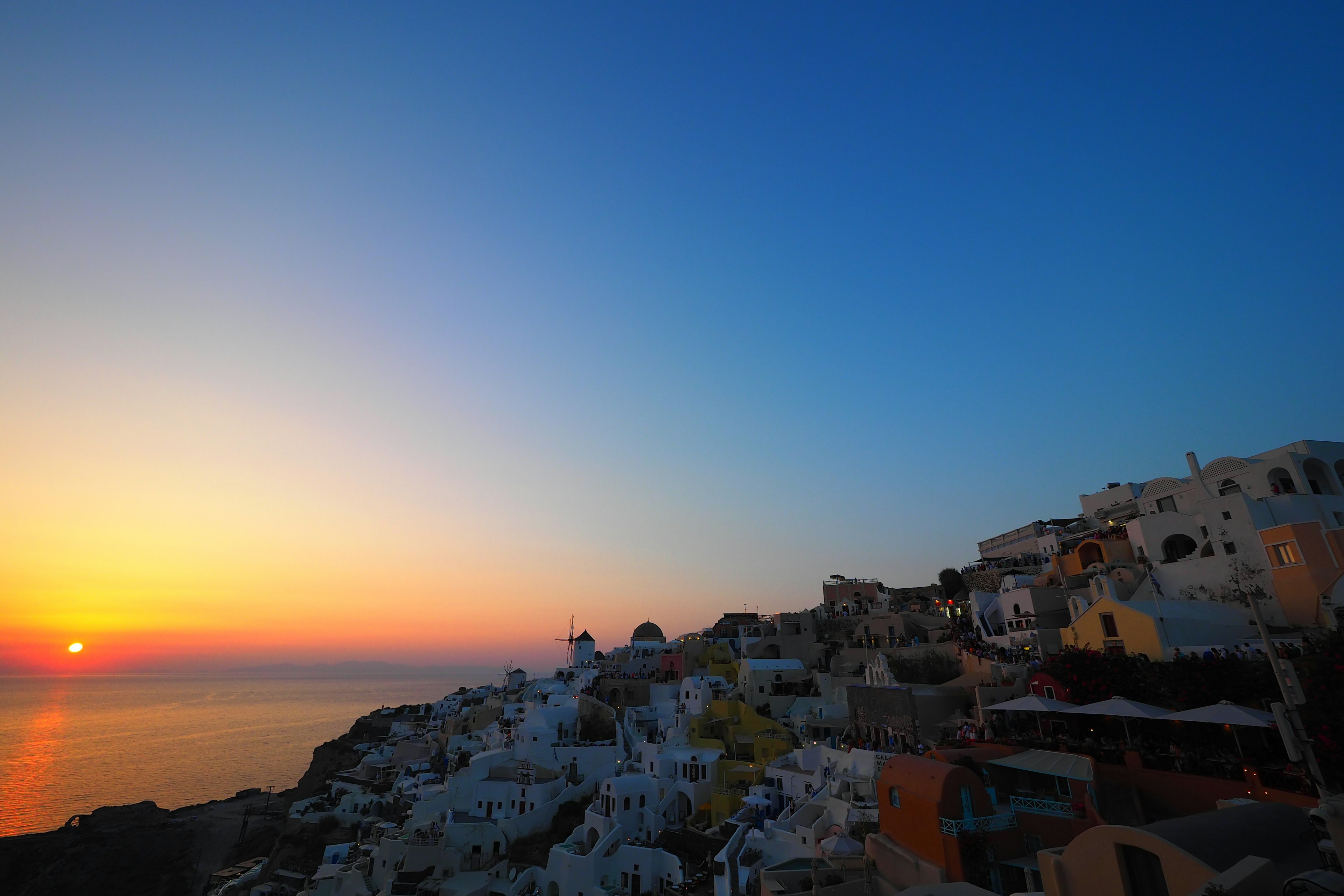 美しいサントリーニ島の夕日と白い建物が並ぶ風景