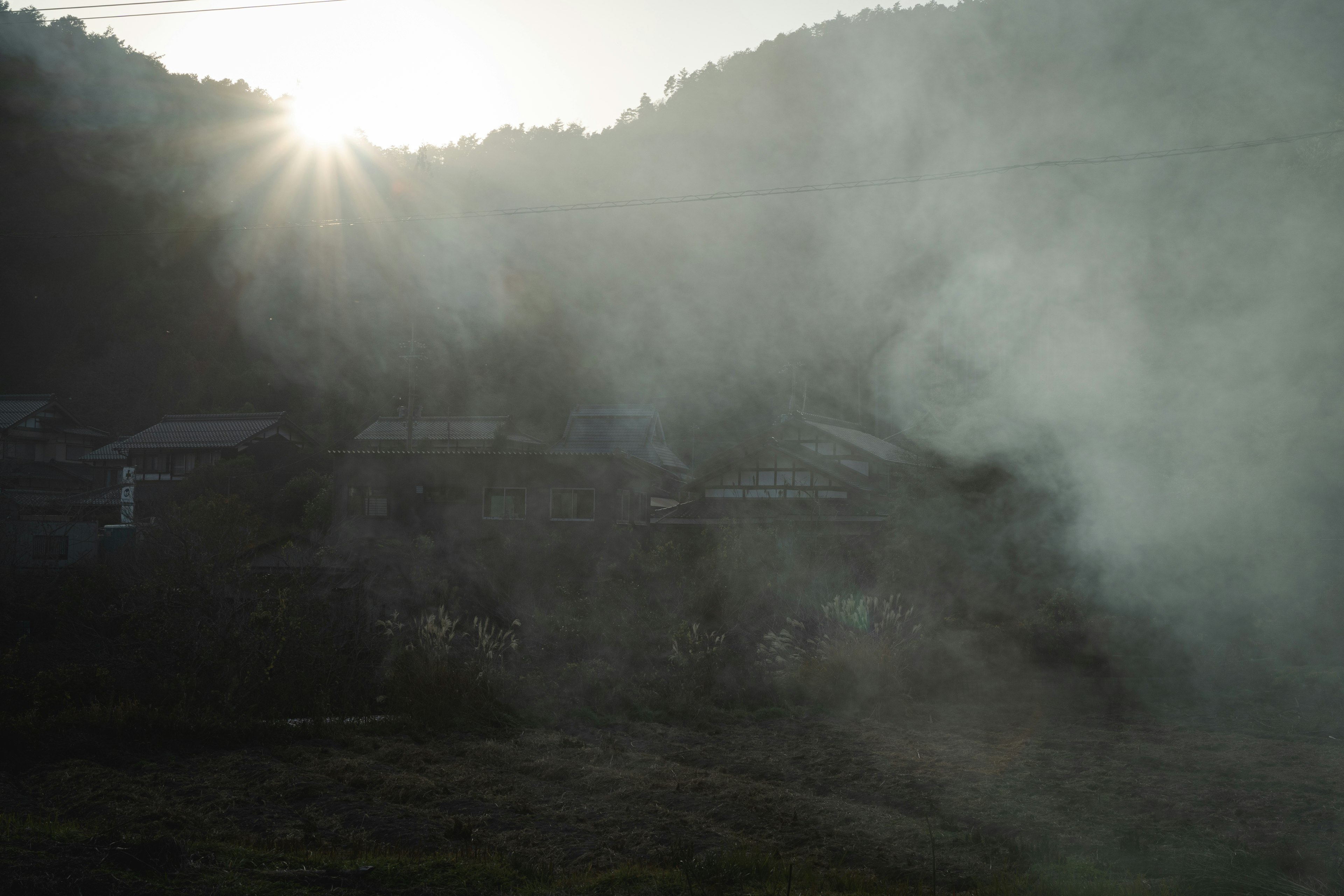 Luz del sol a través de montañas brumosas