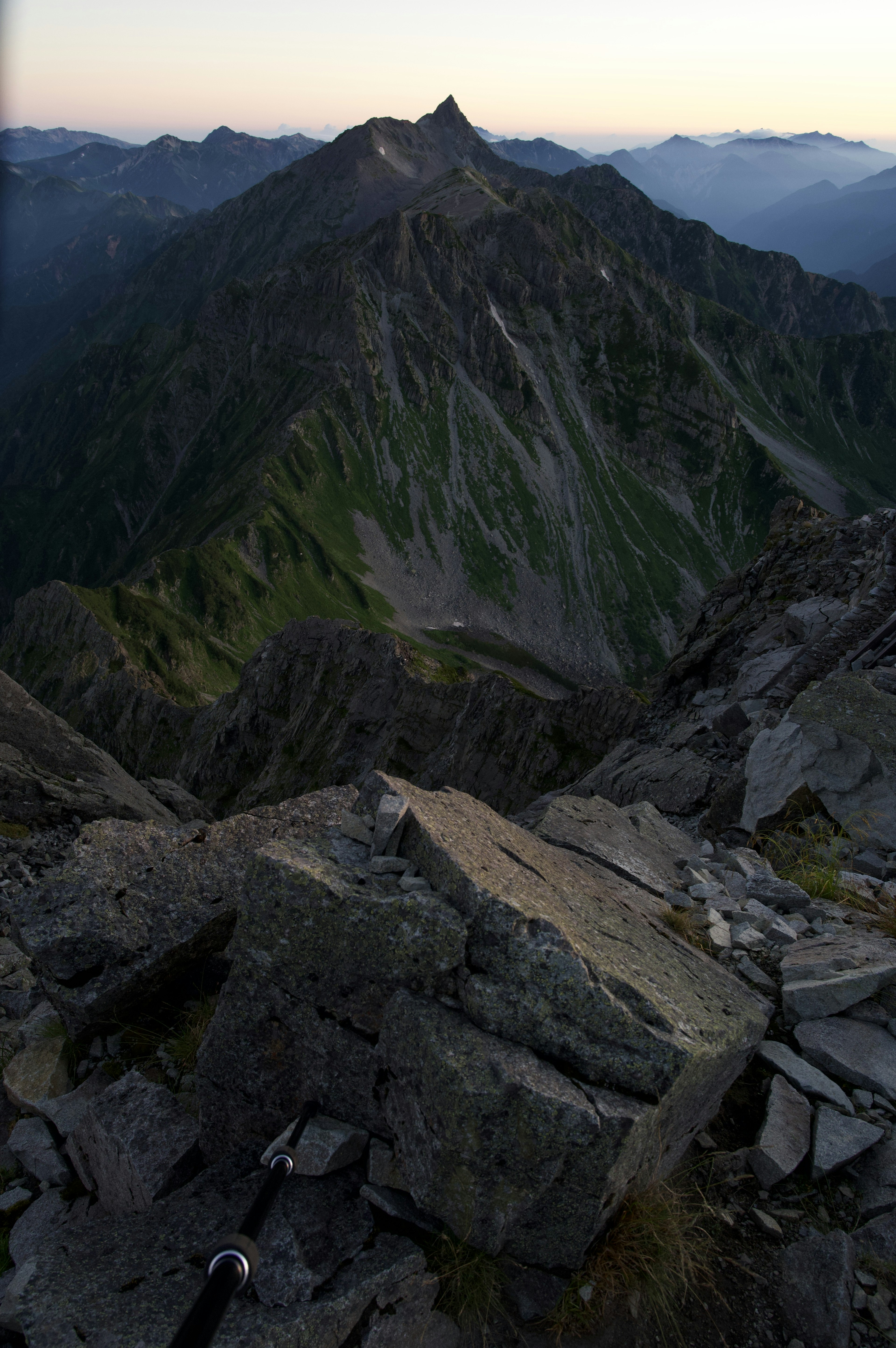 Vue depuis le sommet de la montagne avec un terrain rocheux et des pentes raides