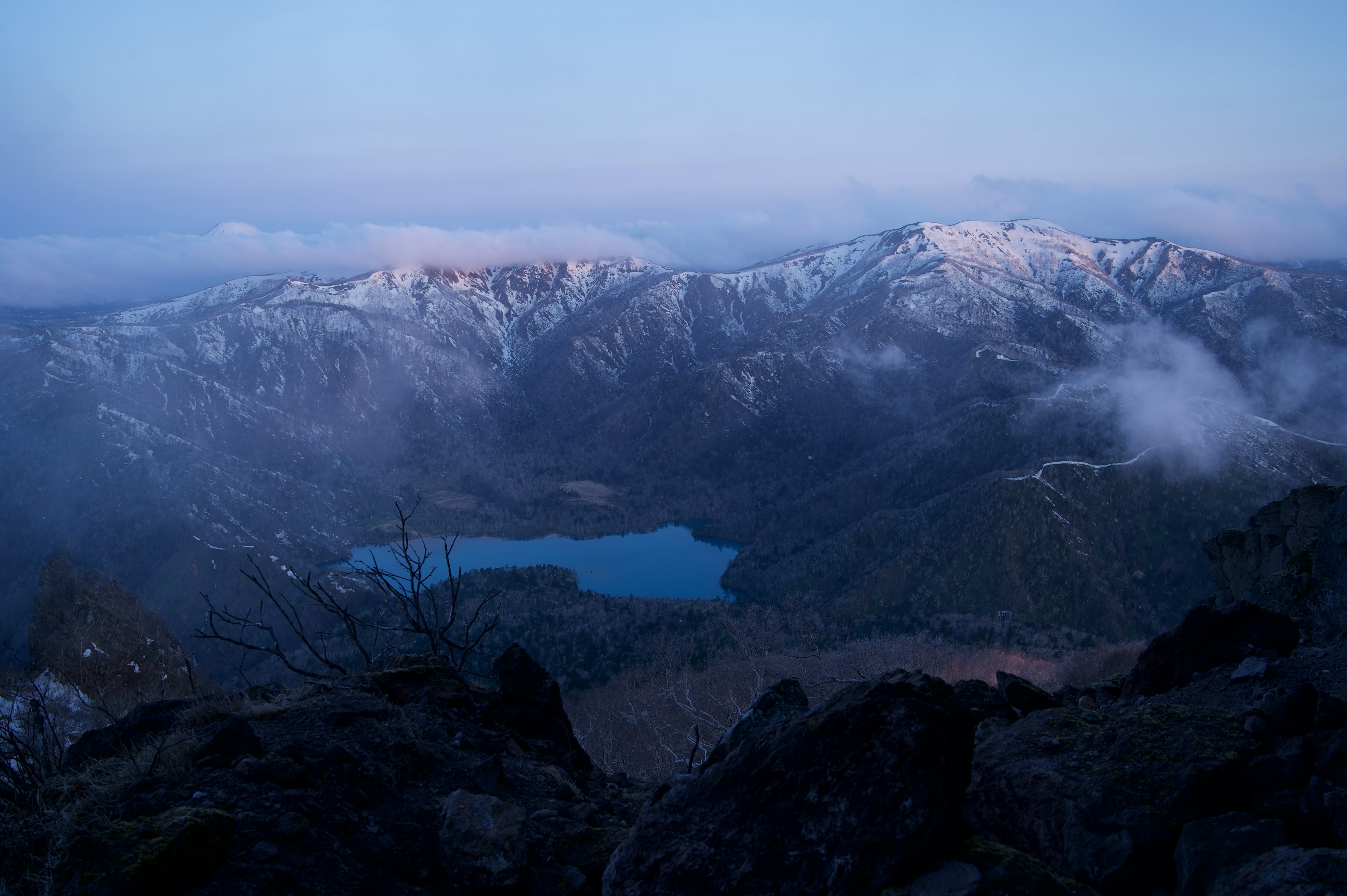 Wunderschöne Landschaft von Bergen und See bei Dämmerung mit blauem Himmel und schneebedeckten Gipfeln