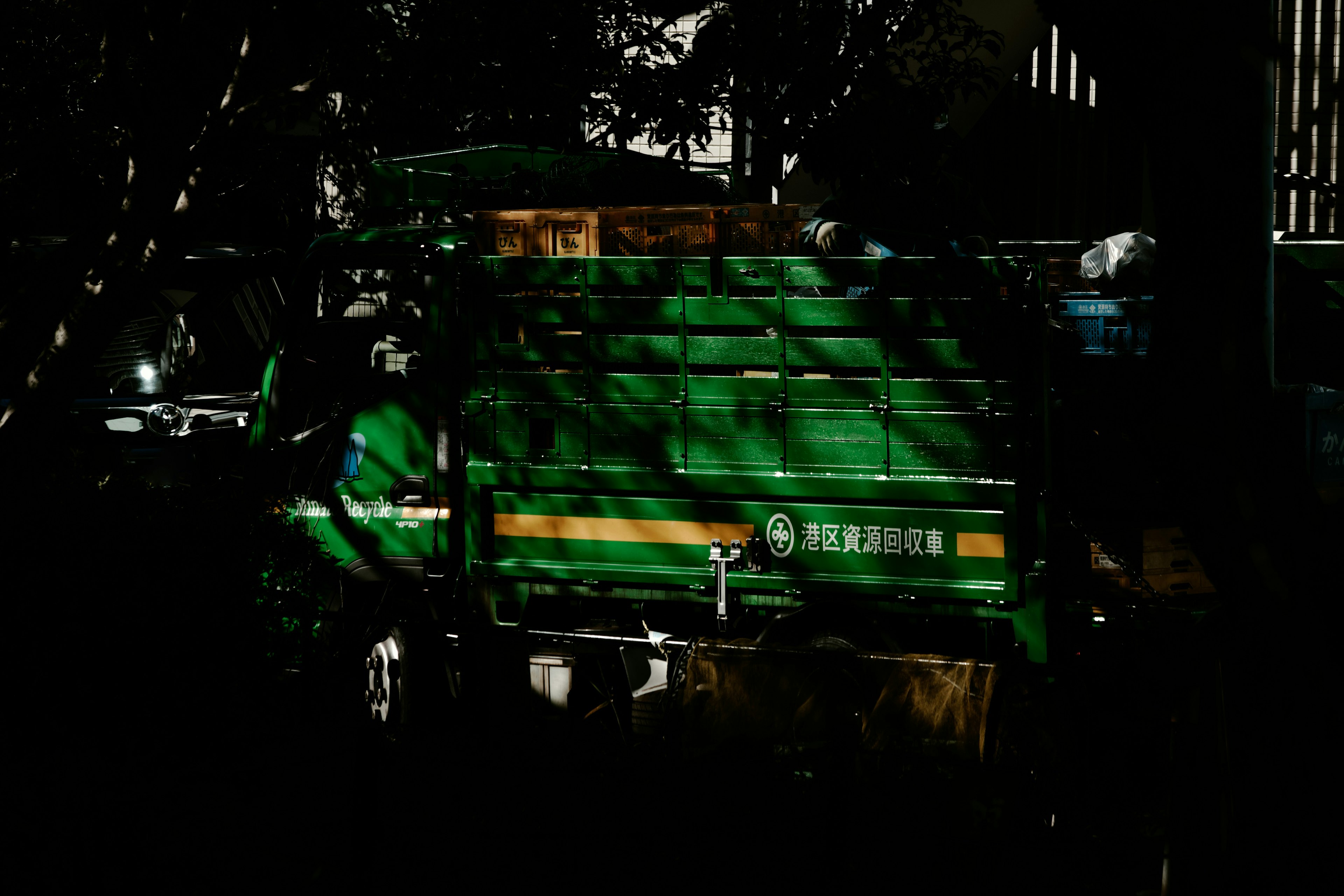 Grüner Lastwagen in einer dunklen Umgebung mit Schatten