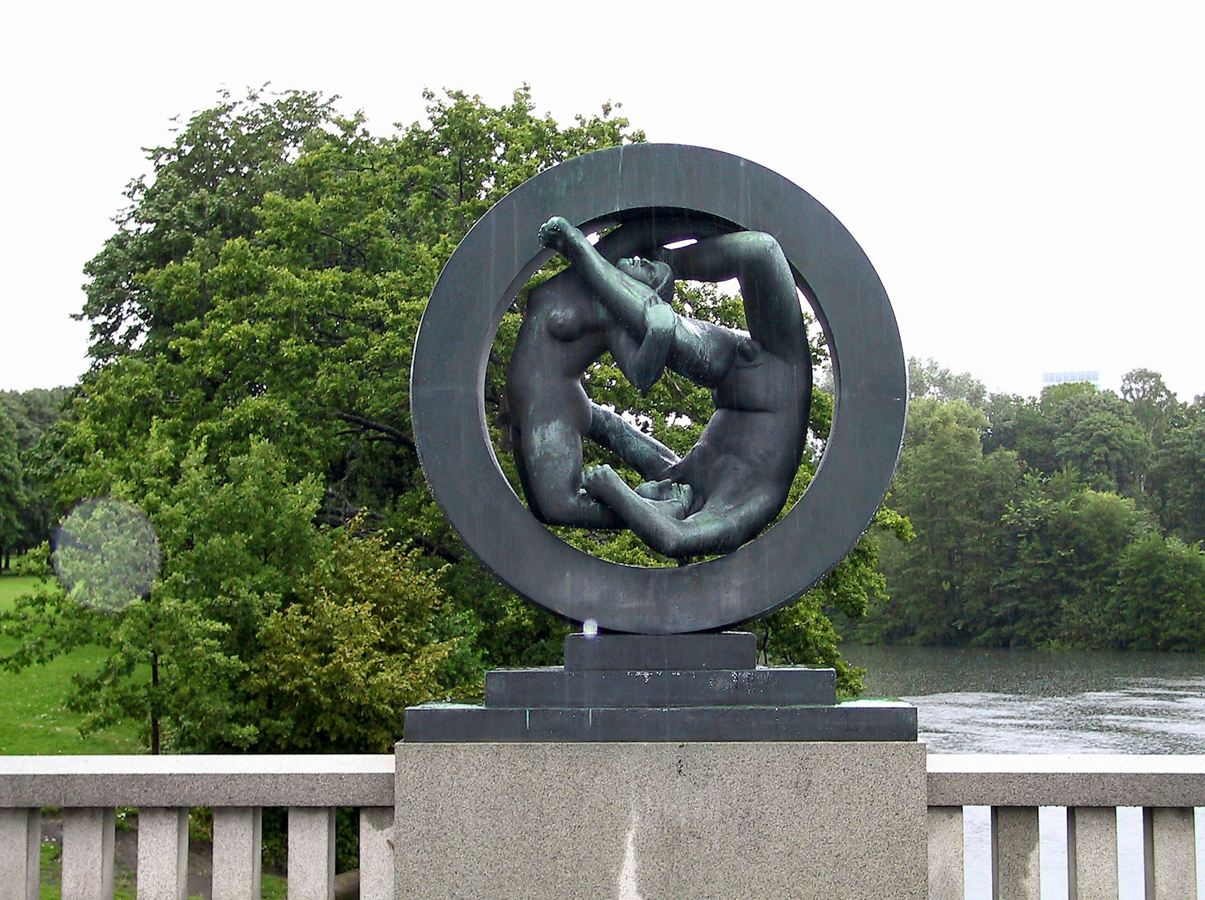 Circular sculpture featuring two figures intertwined in a dynamic pose