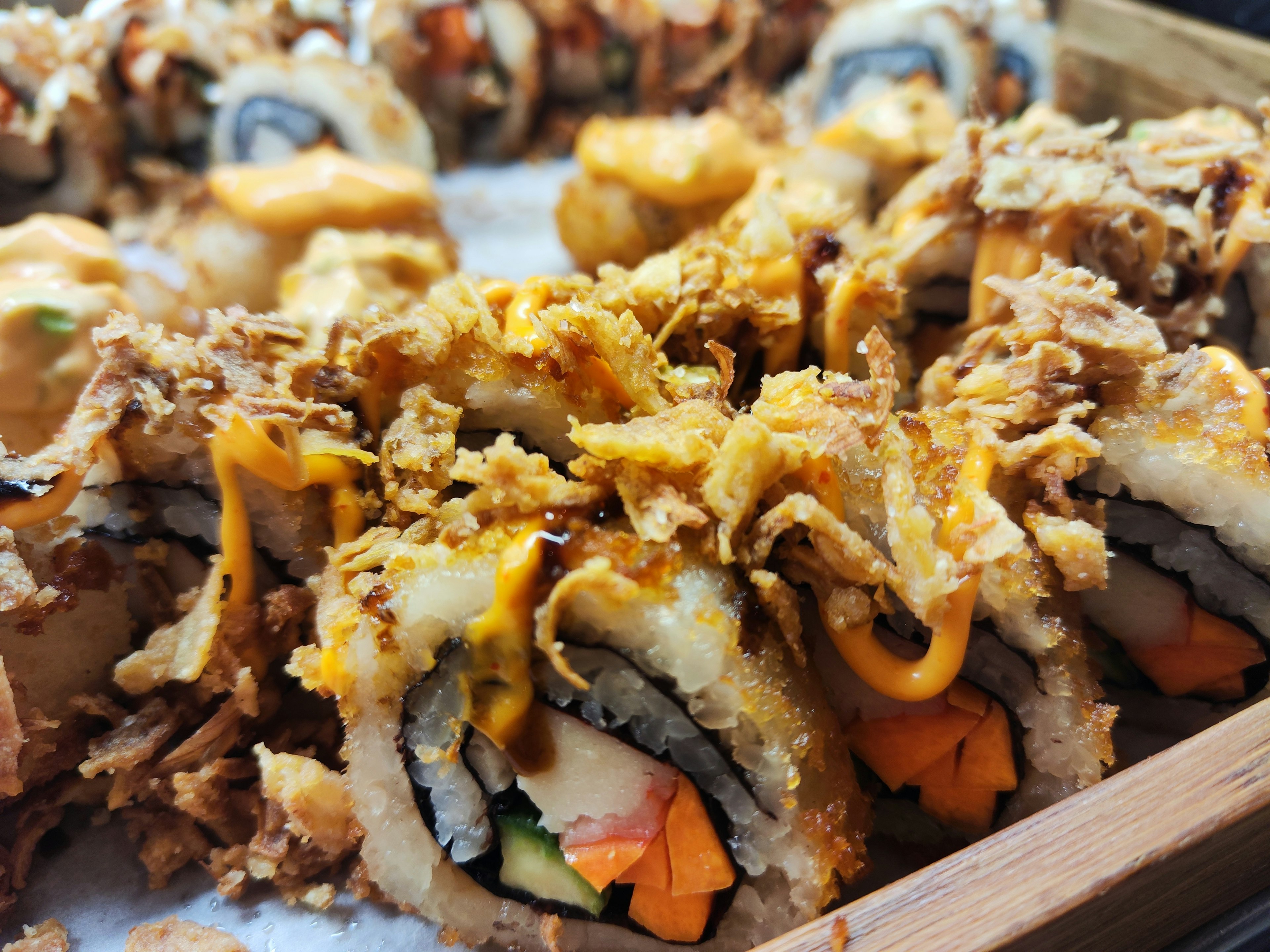 Close-up of fried sushi rolls featuring colorful ingredients and toppings