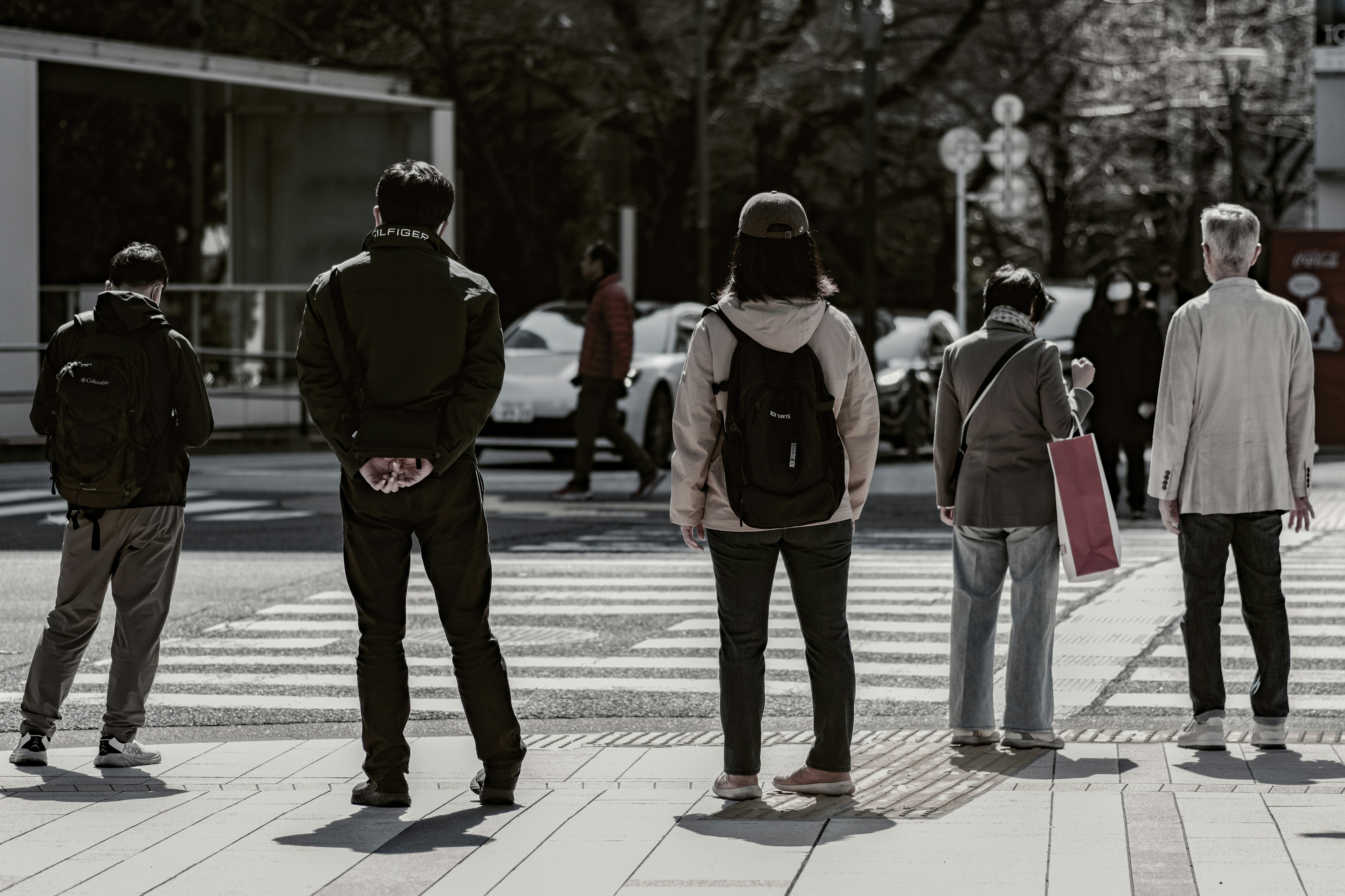 People waiting at a crosswalk in an urban setting