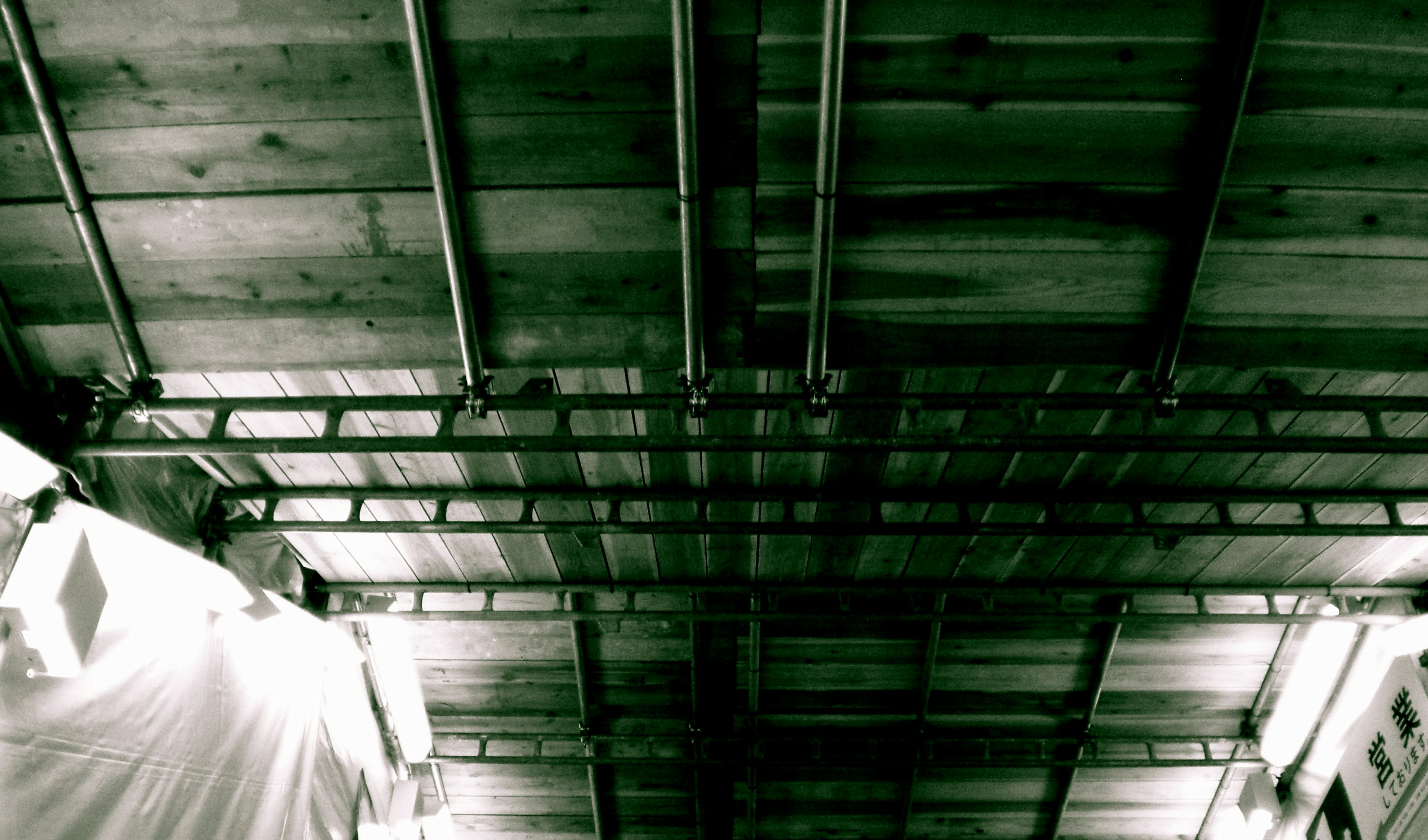 View of a wooden ceiling with metal beams from below