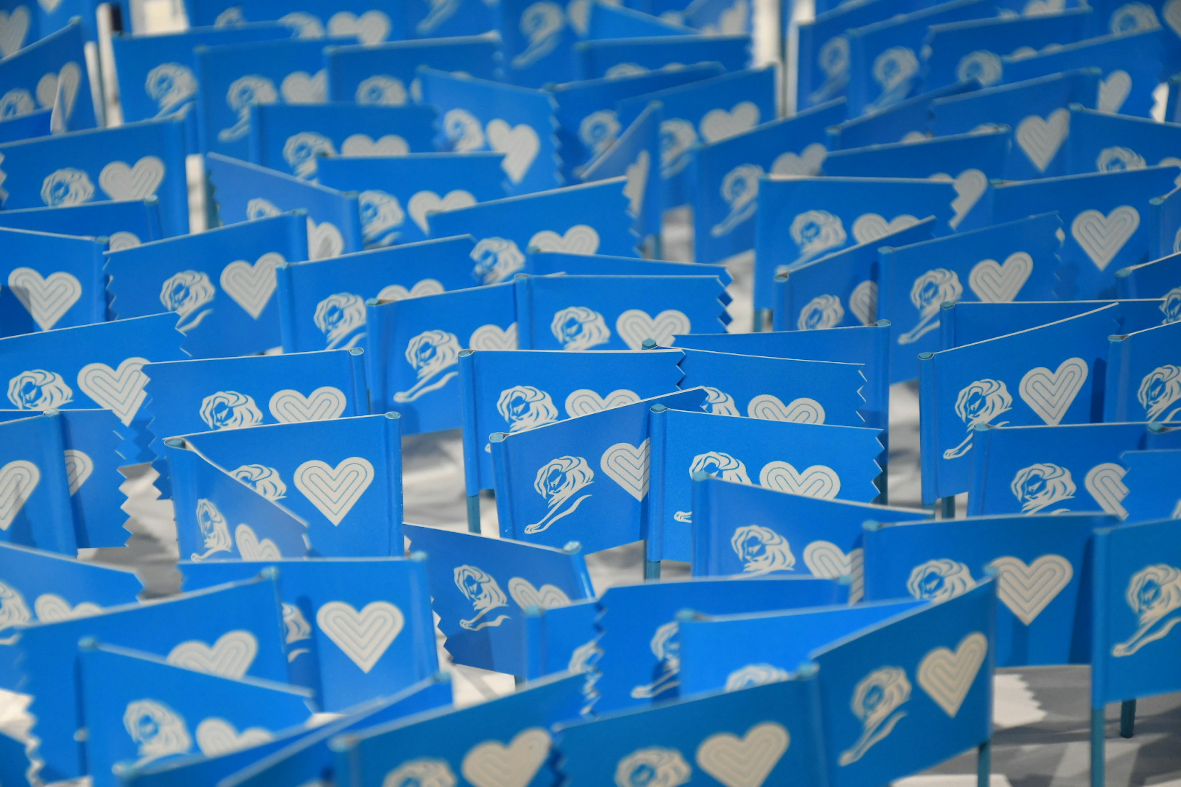 A field of blue flags displaying heart symbols and logos