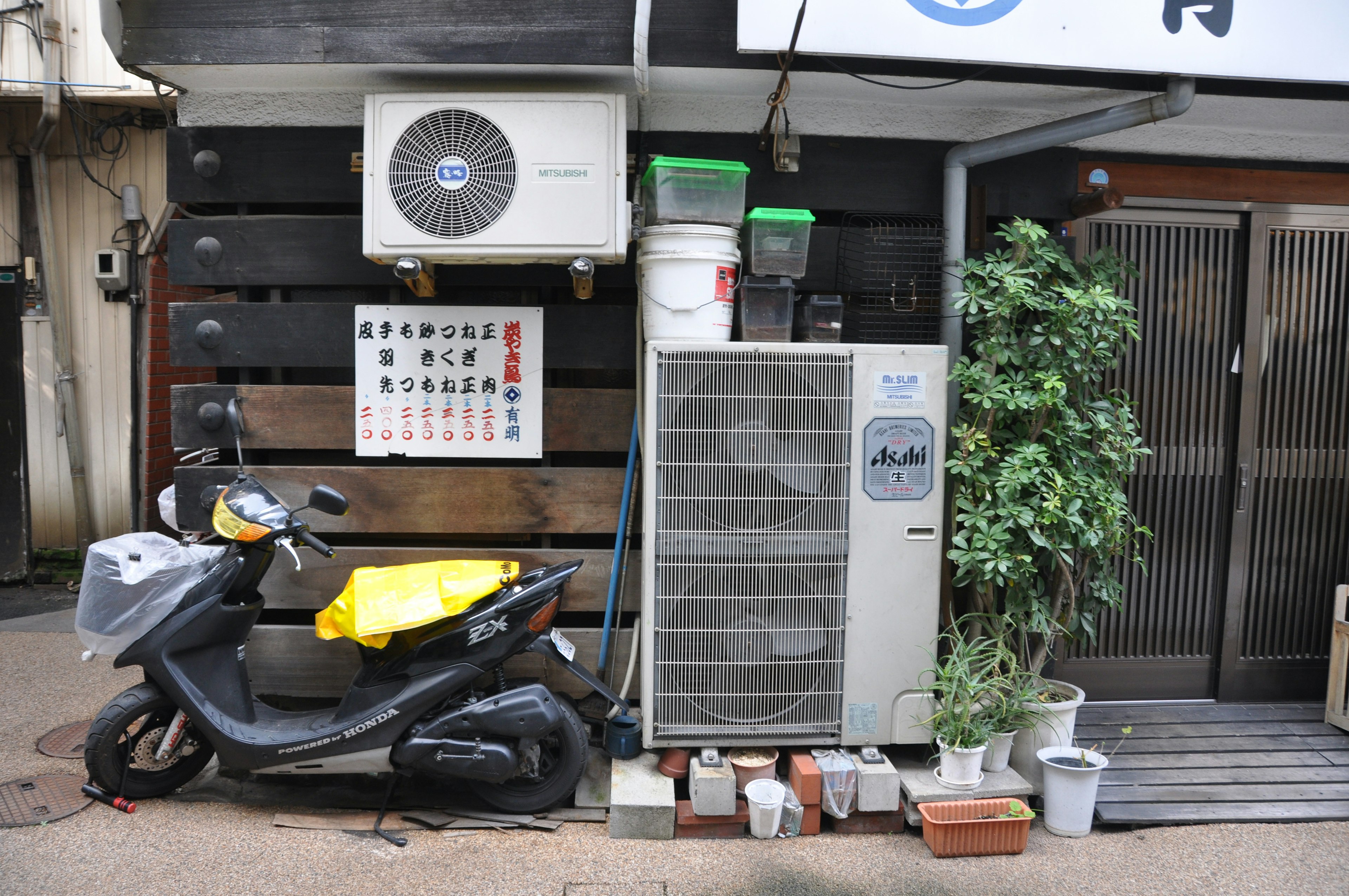 商店の外にあるエアコンとスカートが置かれたバイク