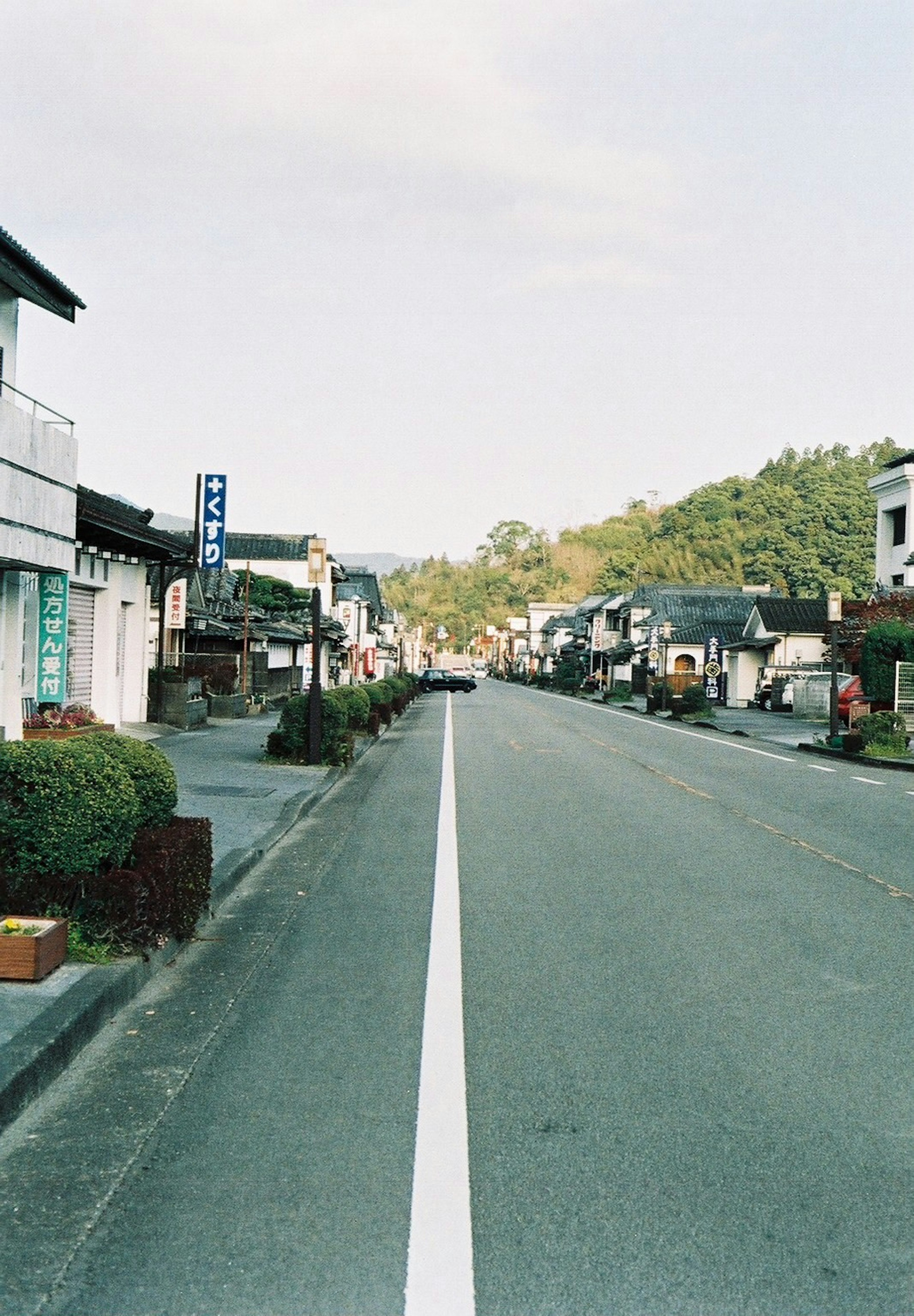 Quiet street view with traditional buildings and green hills