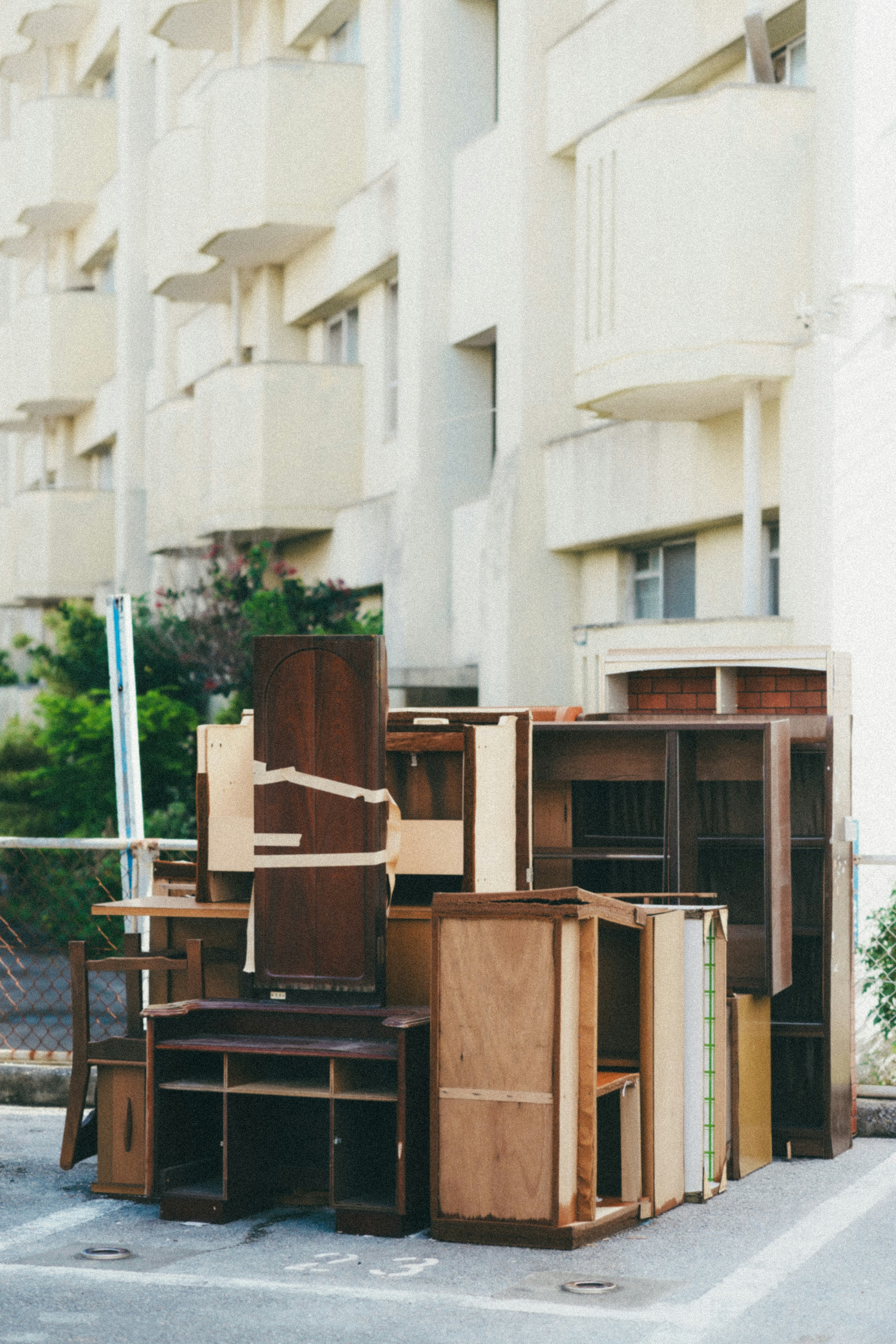 Una pila de muebles viejos apilados frente a un edificio de apartamentos