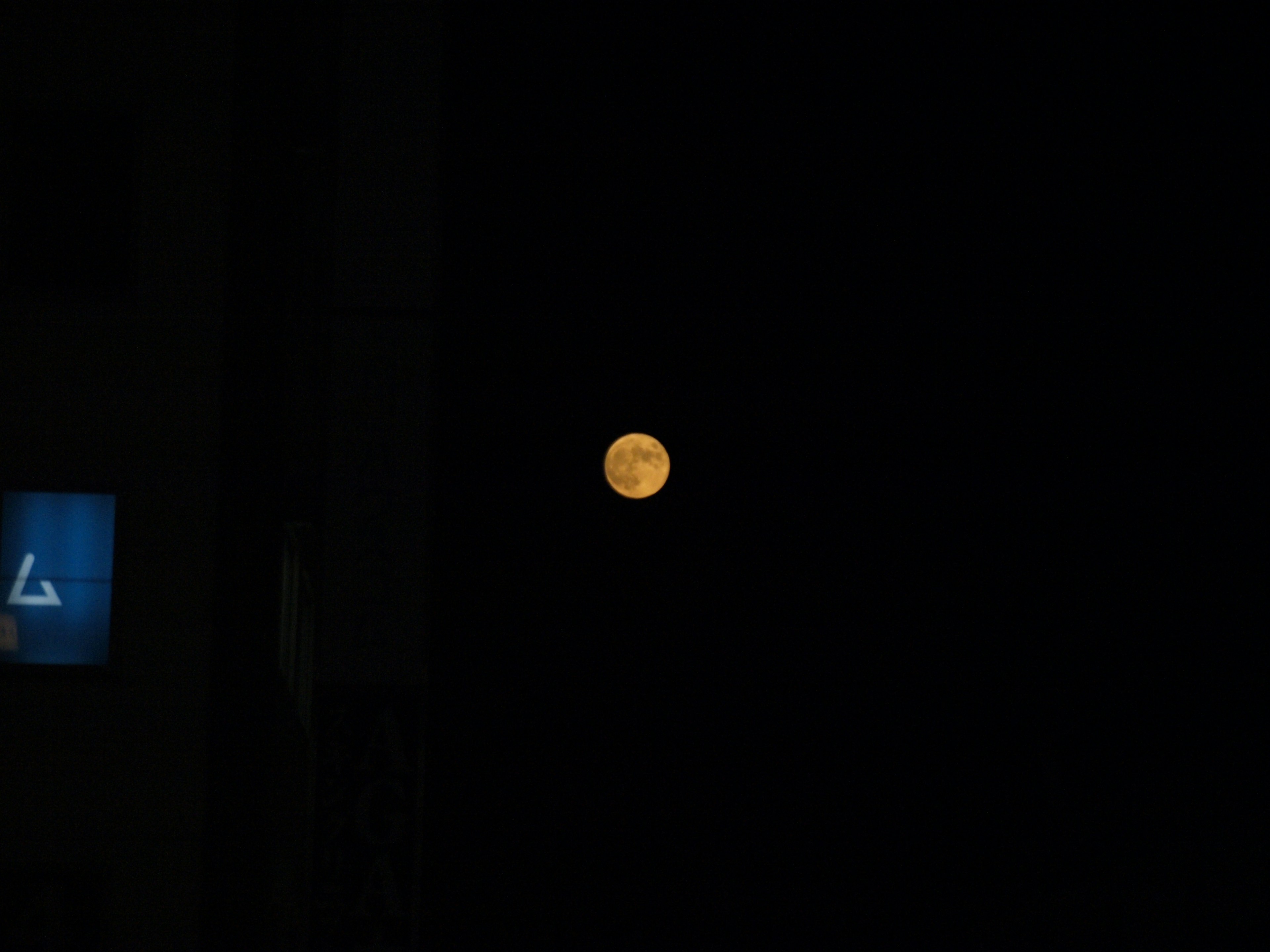 Lune orange flottant sur un fond sombre